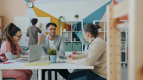 A group of people working together at a table in a colorful office