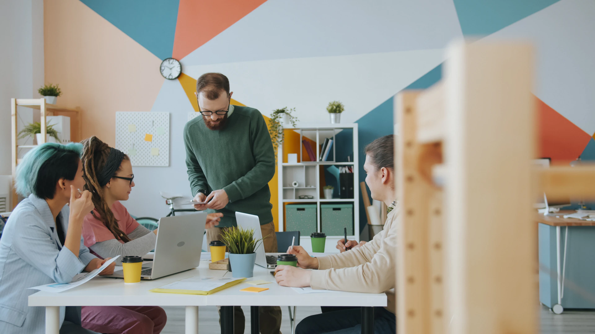 A group of people working together at a table in a colorful office