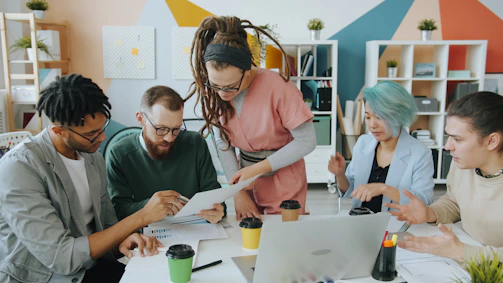 A group of people collaborating on documents at a table in a workspace