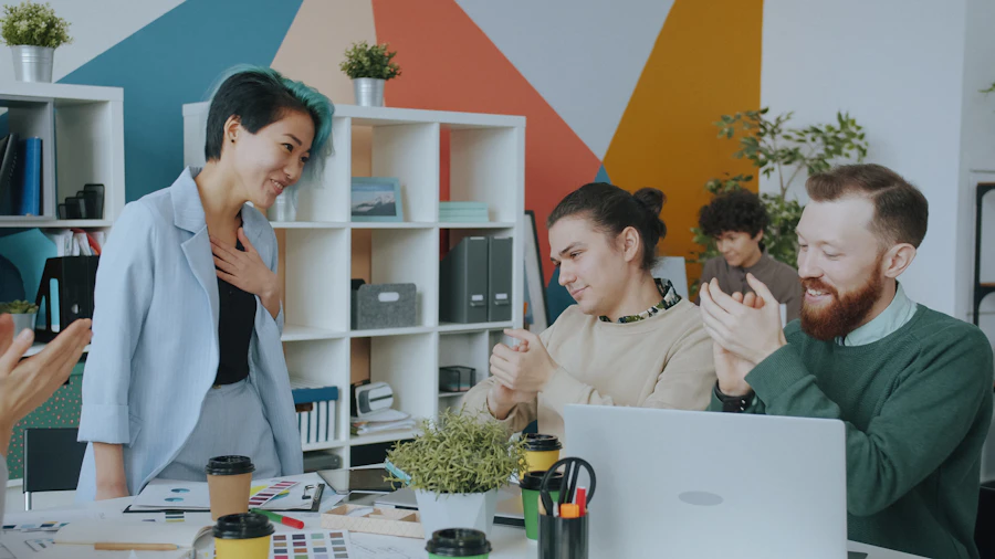 L'équipe d'un studio de design applaudit dans un bureau coloré