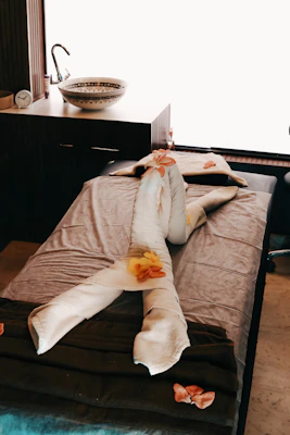 Towels folded into swans on massage table with flowers