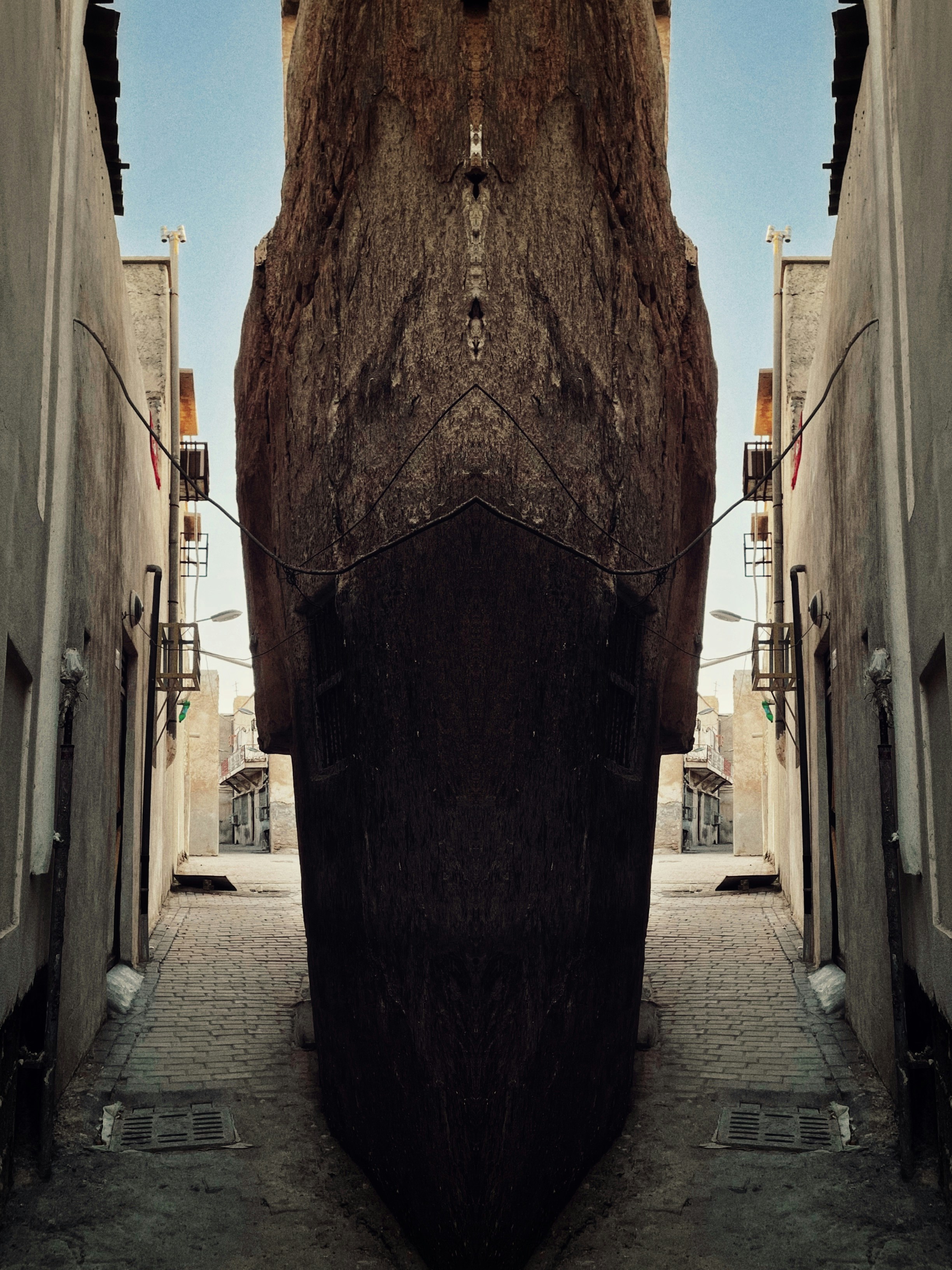 A symmetrical view of a narrow alleyway between tall stone walls