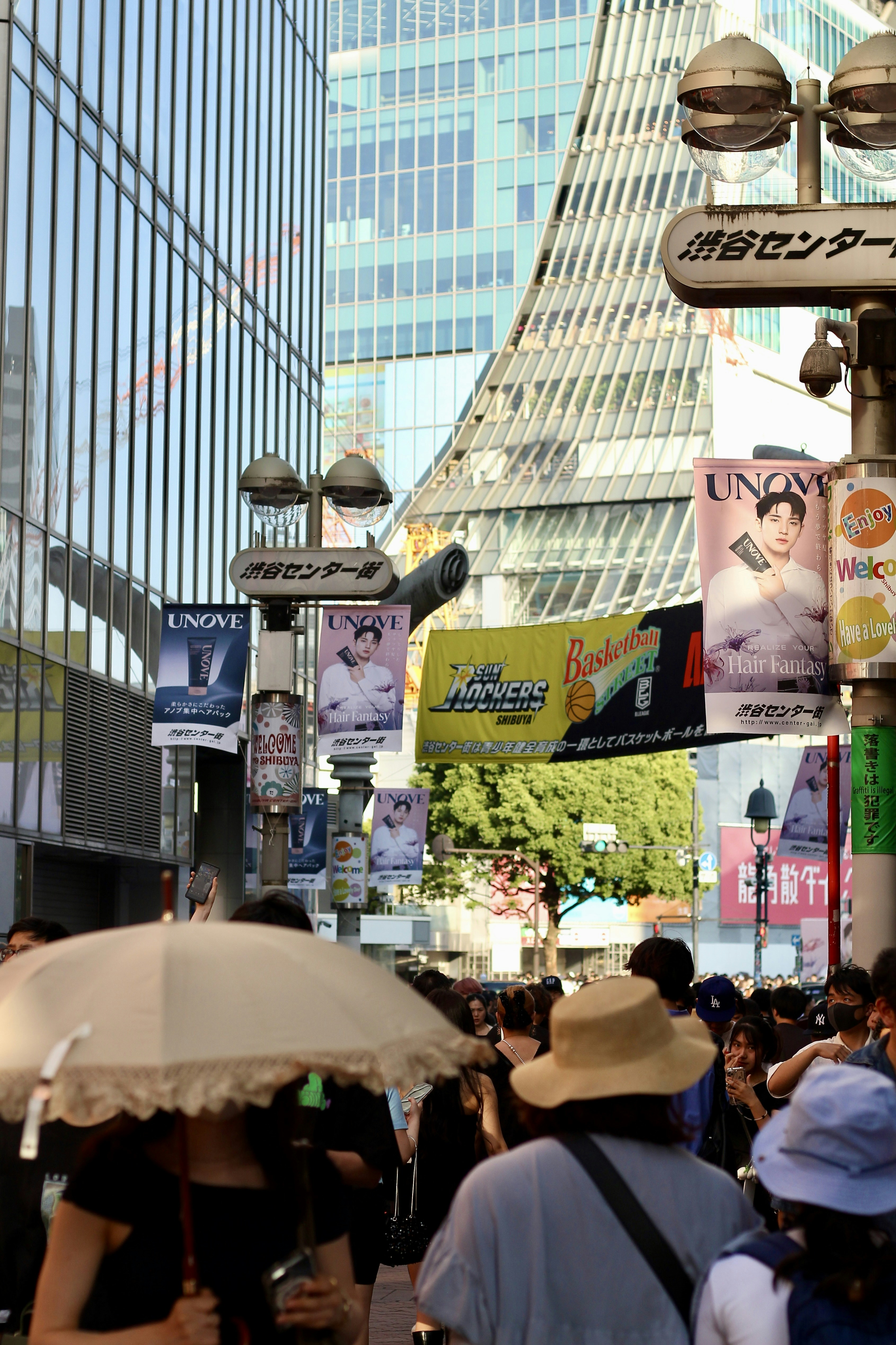 Crowd of people walking under hanging banners on a busy street in Shibuya, Tokyo