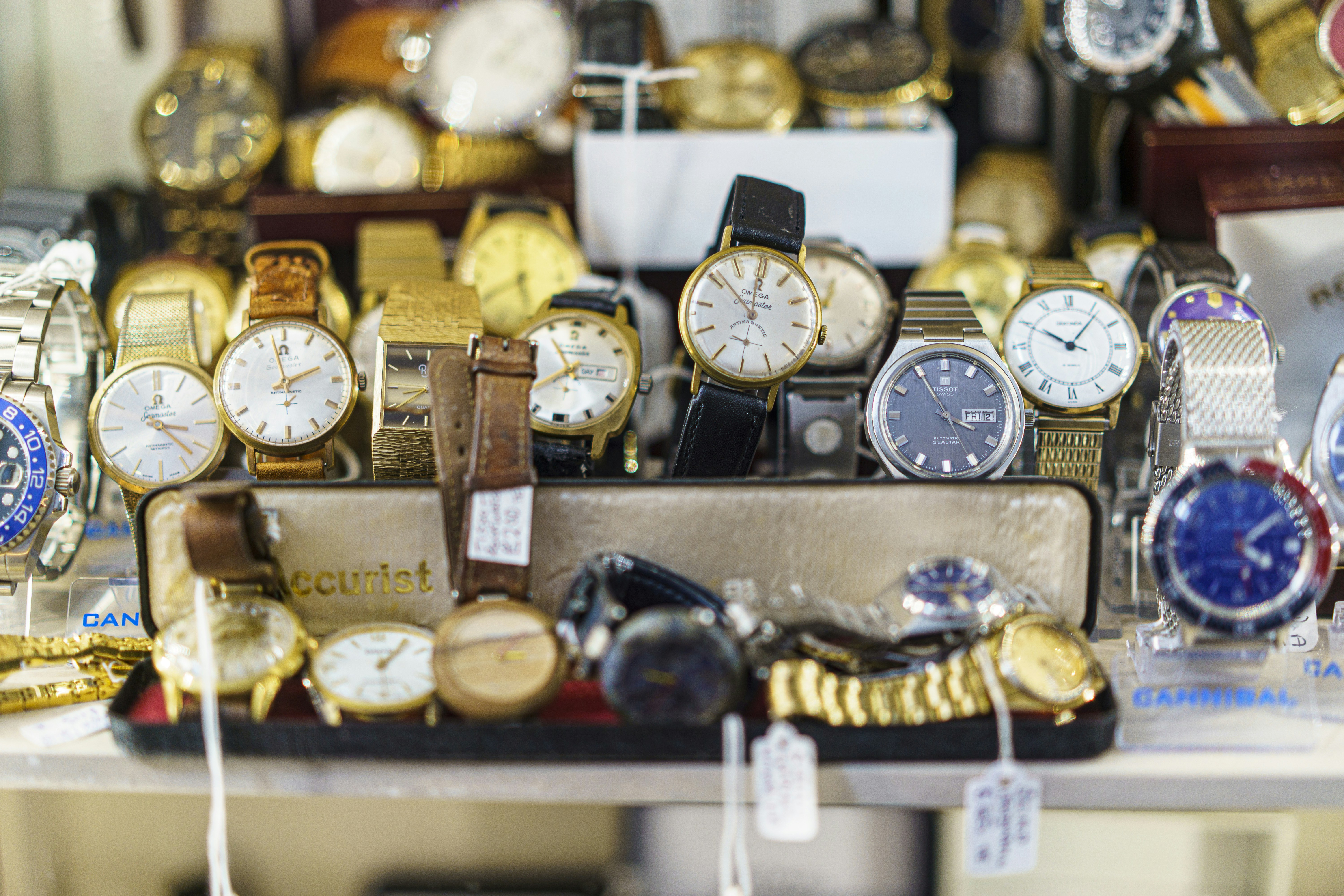 A collection of vintage wristwatches with leather and metal bands on display