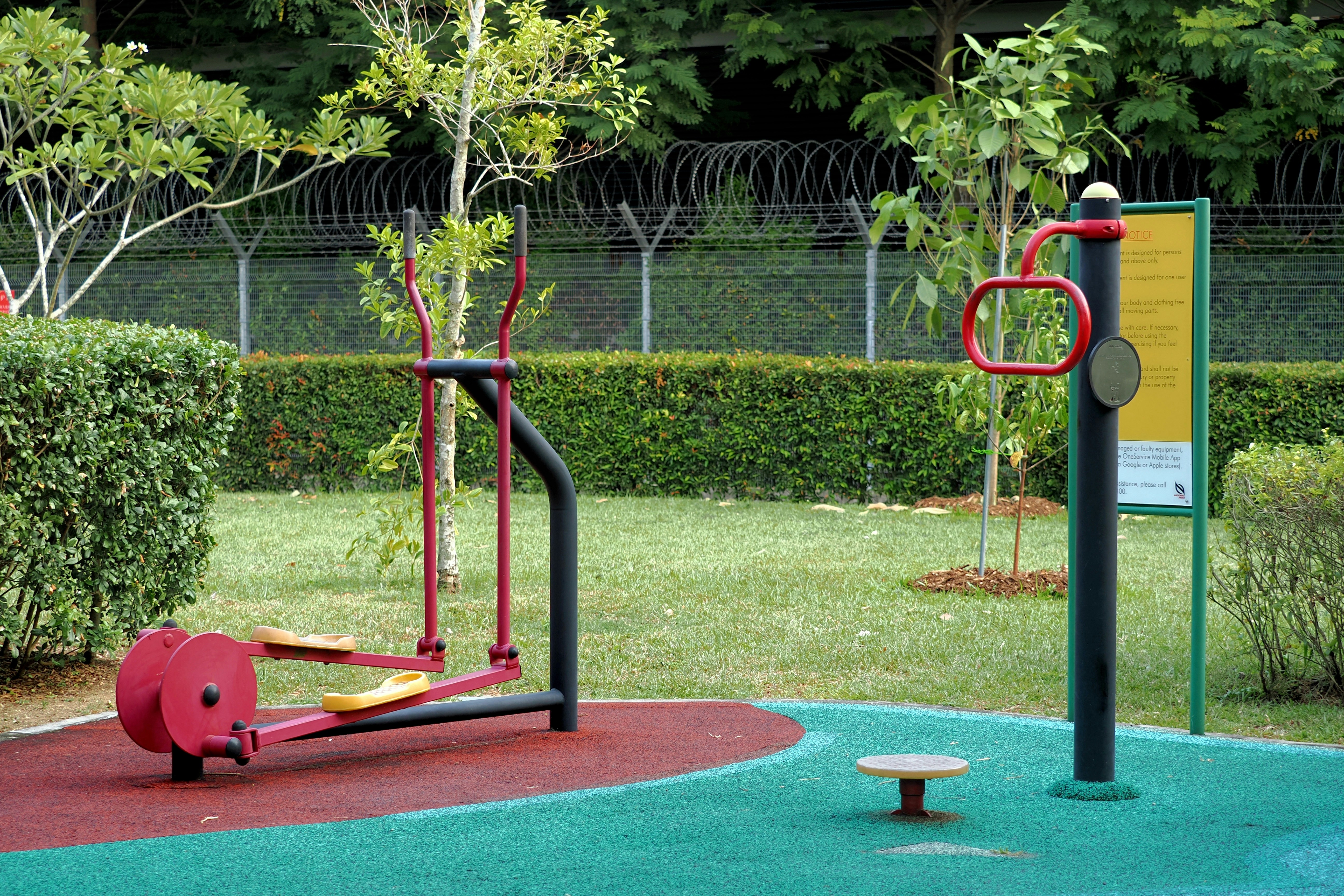 Outdoor fitness equipment on a colorful rubber surface in a park