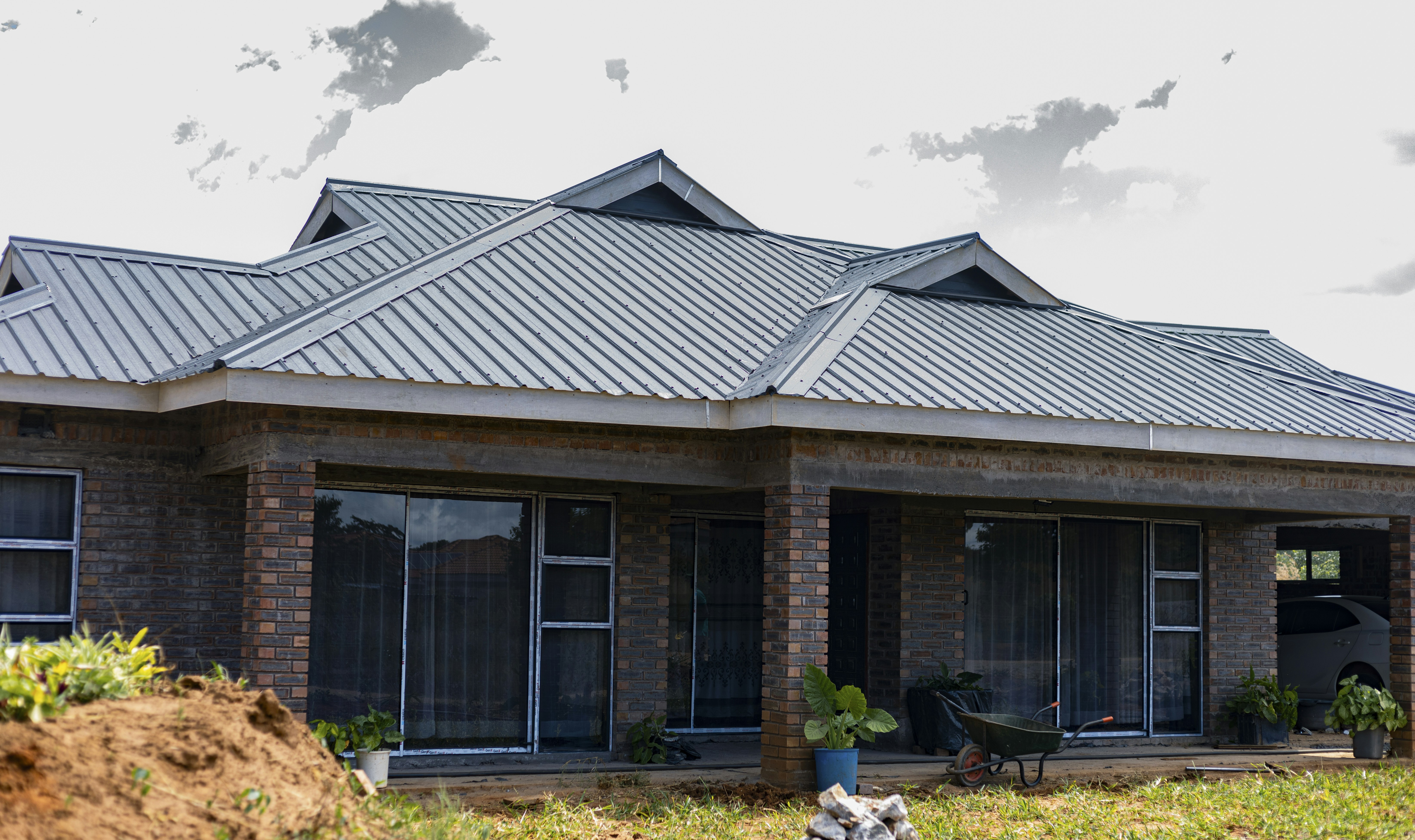 A brick house with a grey metal roof and sliding glass doors