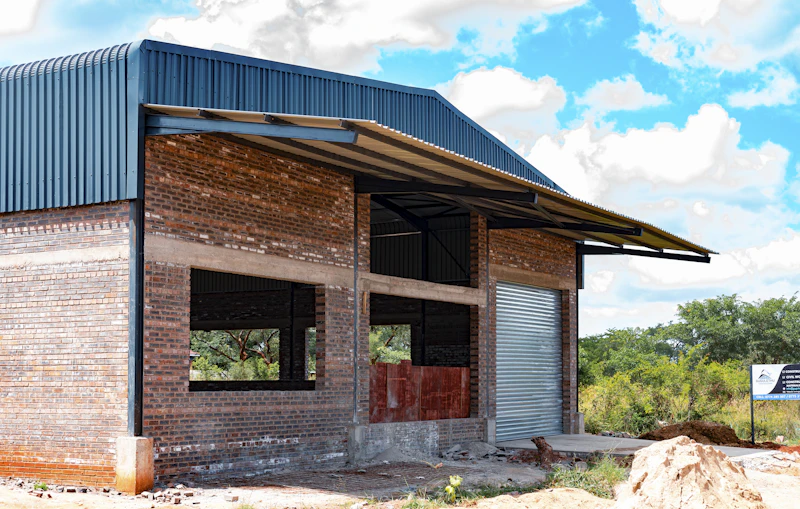 Commercial retail building under construction with steel roof sheeting in progress