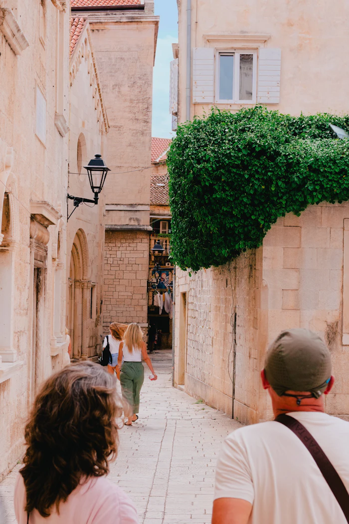 Travelers walking down a narrow historic alley