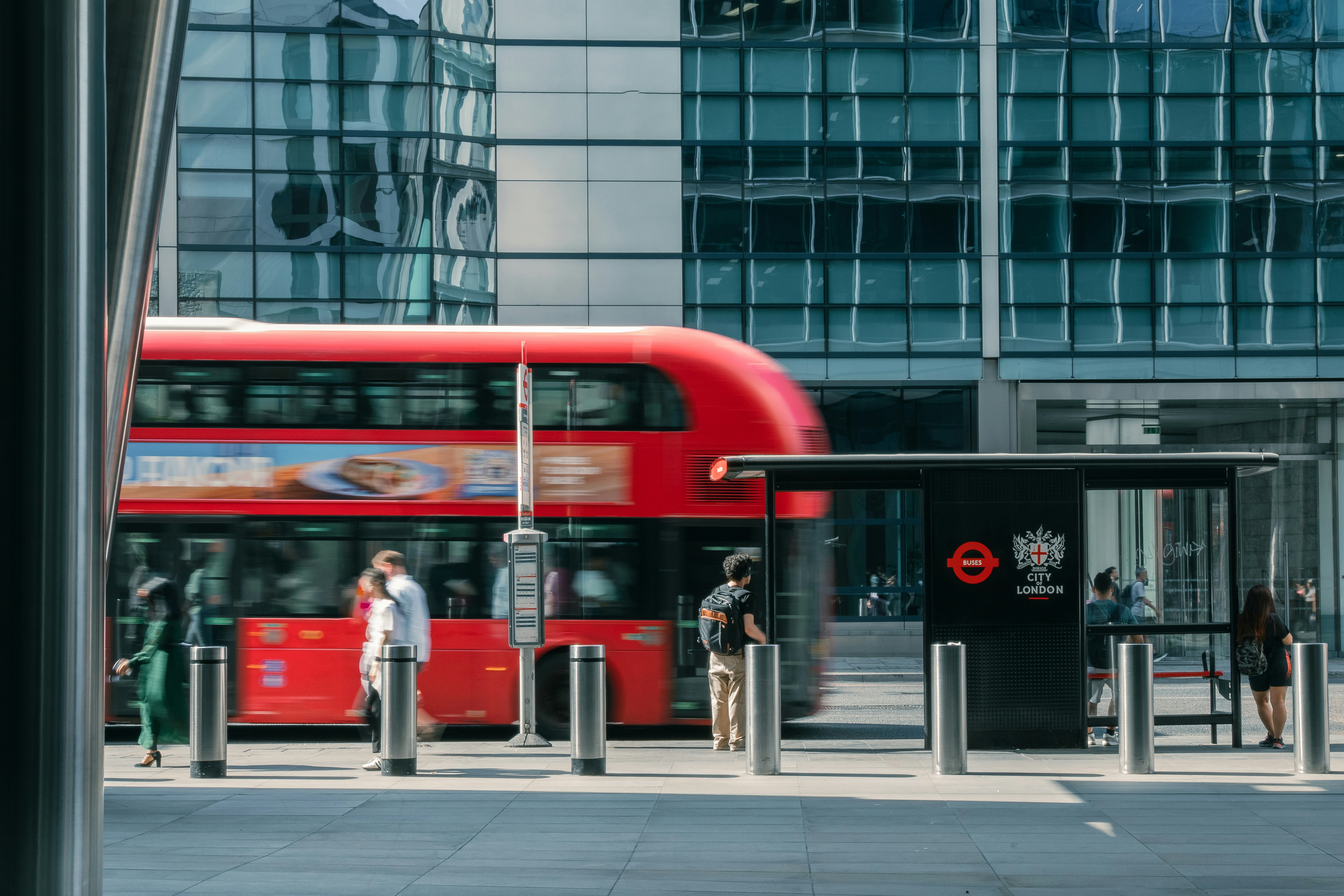 Sebuah bus tingkat merah melewati halte bus di Kota London