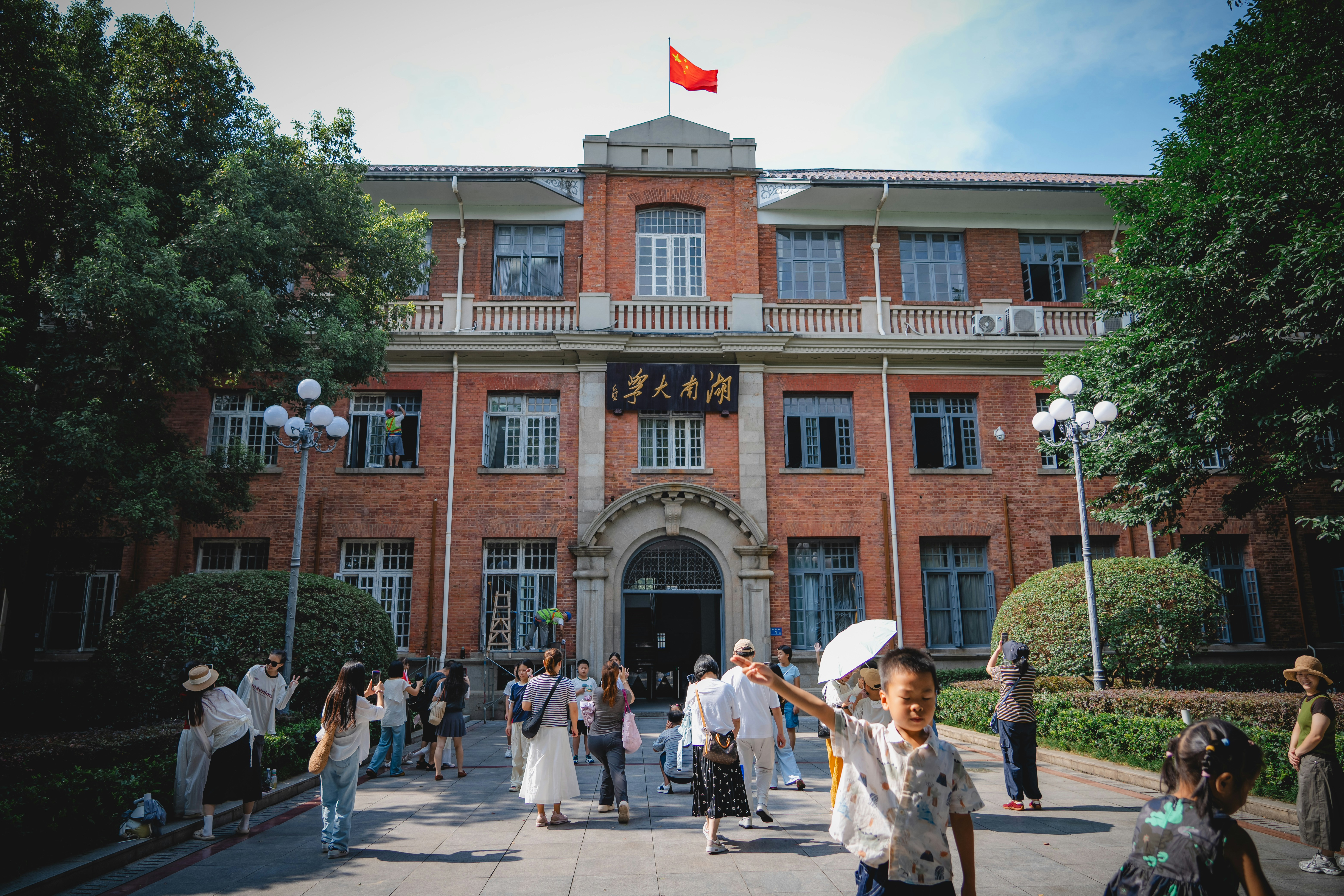 People visiting the historic red brick Hunan University building in Changsha