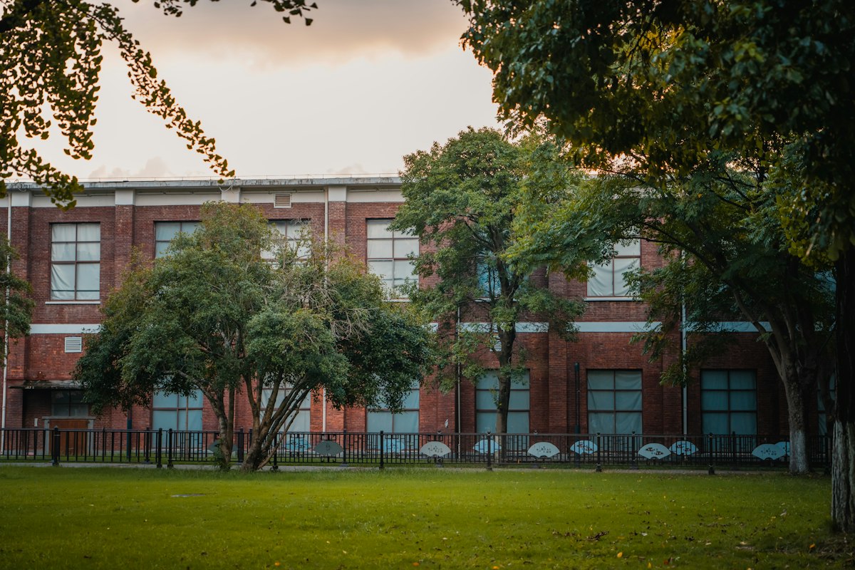 Brick school building behind a lawn at golden hour