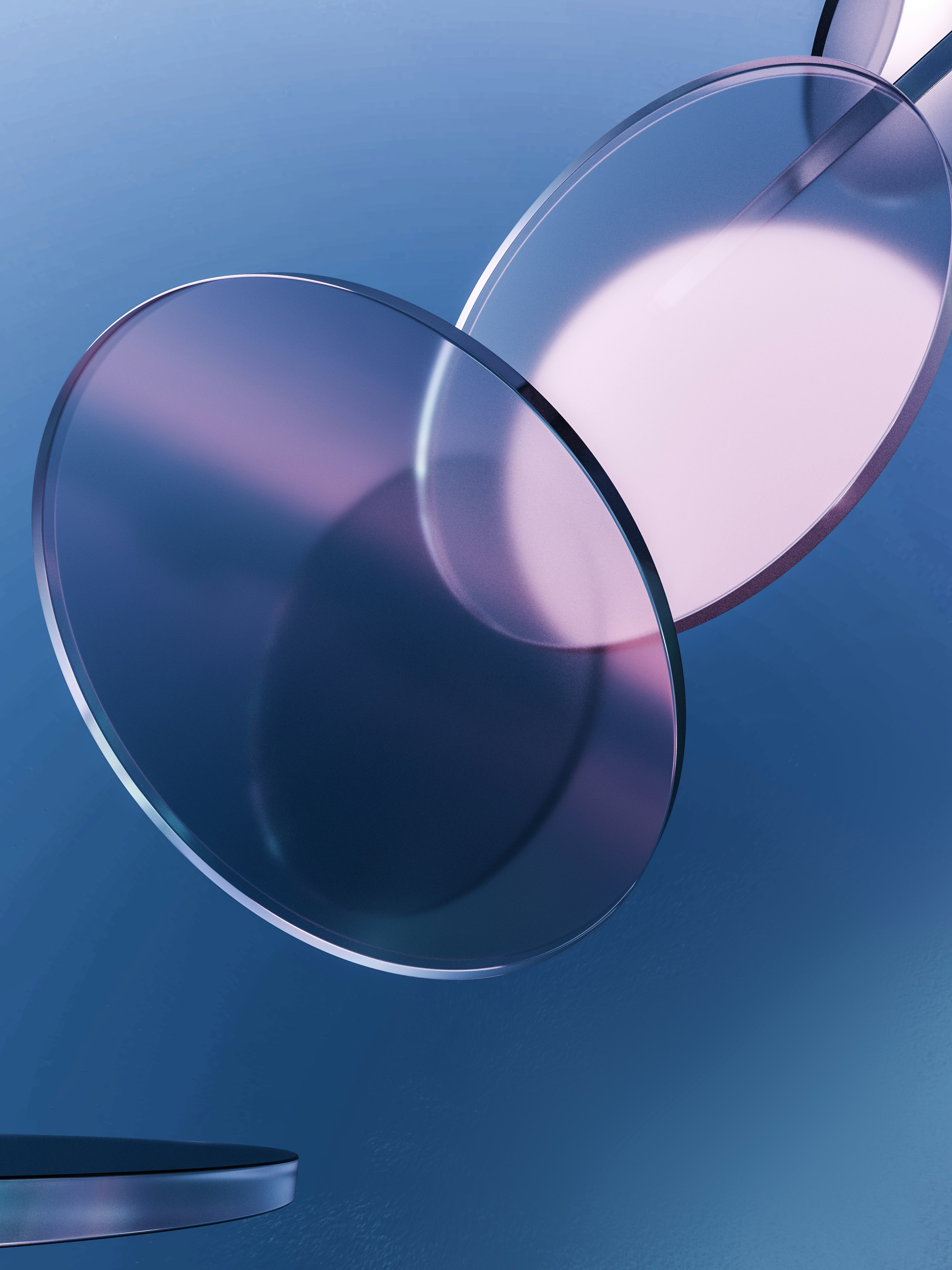 Two translucent glass circles overlapping against a smooth blue background with soft light