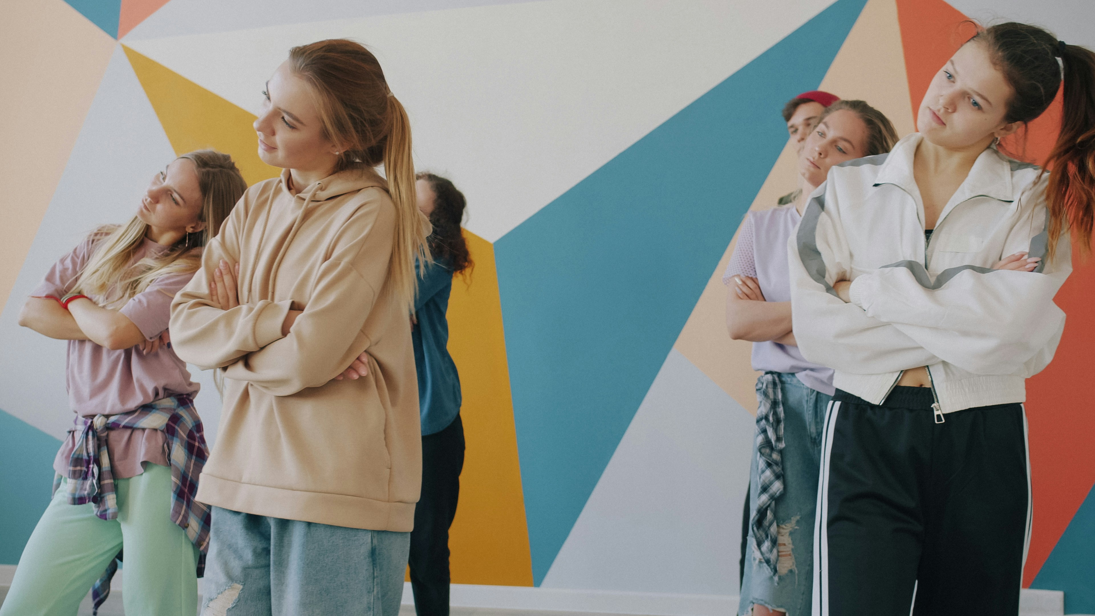 Creative young people in stylish clothing are learning to dance in hip-hop class moving arms and bodies. Modern culture, education and art concept.