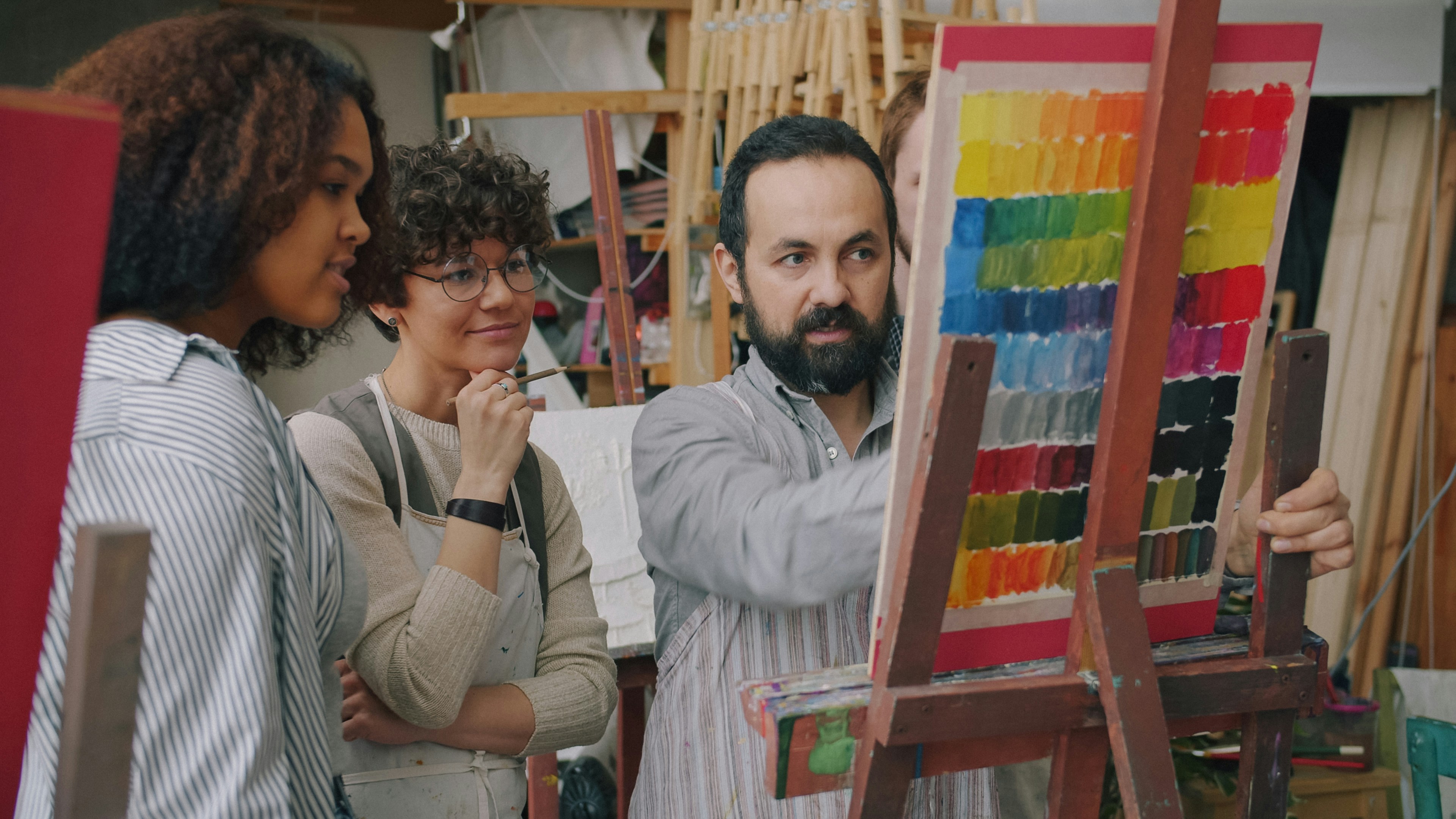 A man and two women looking at a color chart on an easel