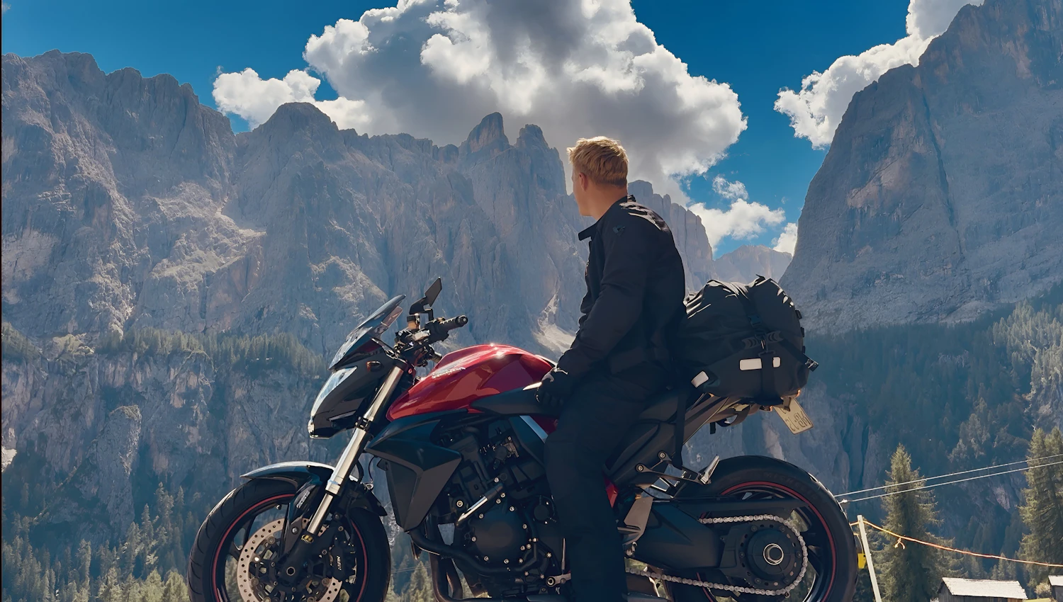 Rider on a red motorcycle stopped to look at jagged peaks