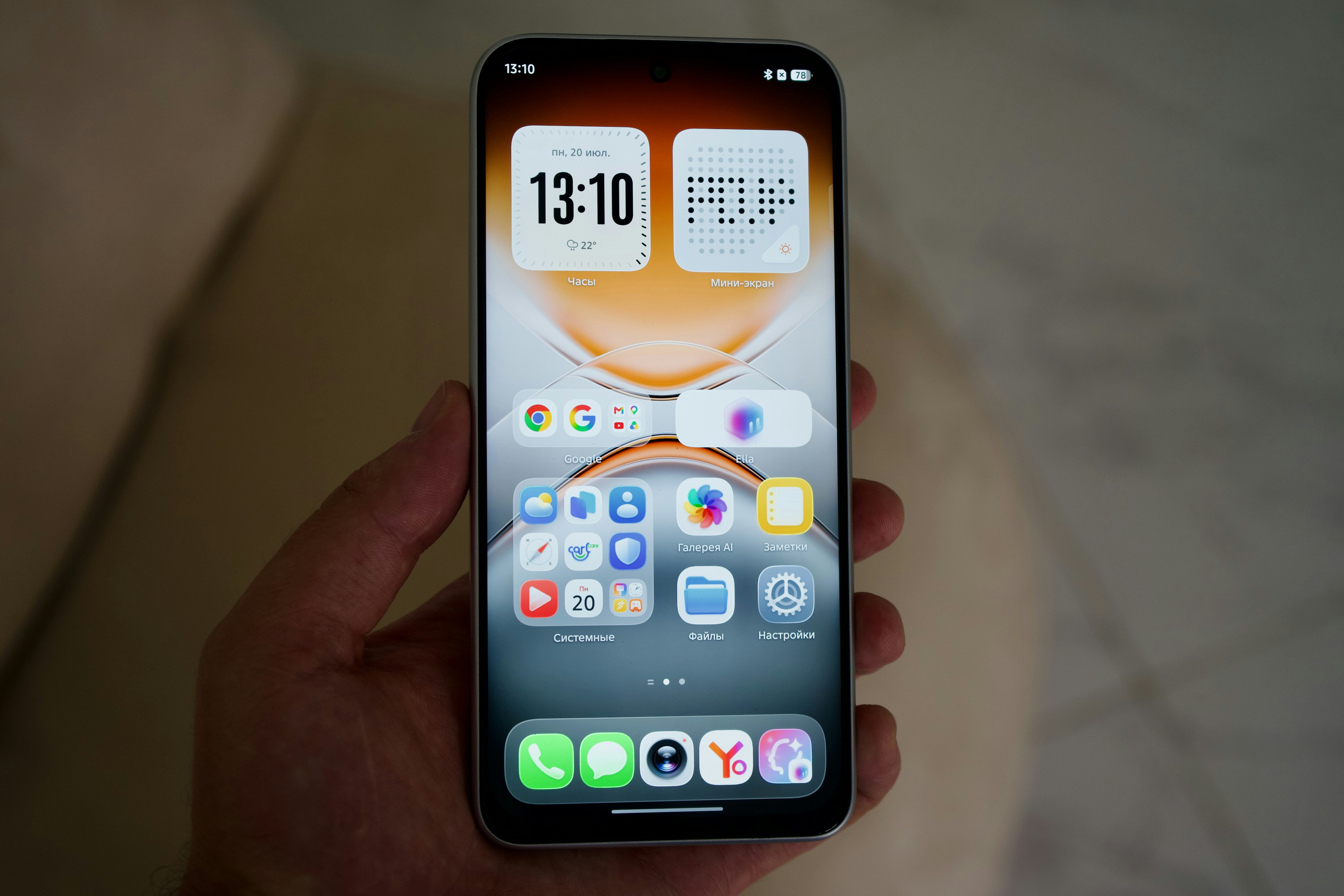 A hand holding a smartphone displaying a home screen with various app icons