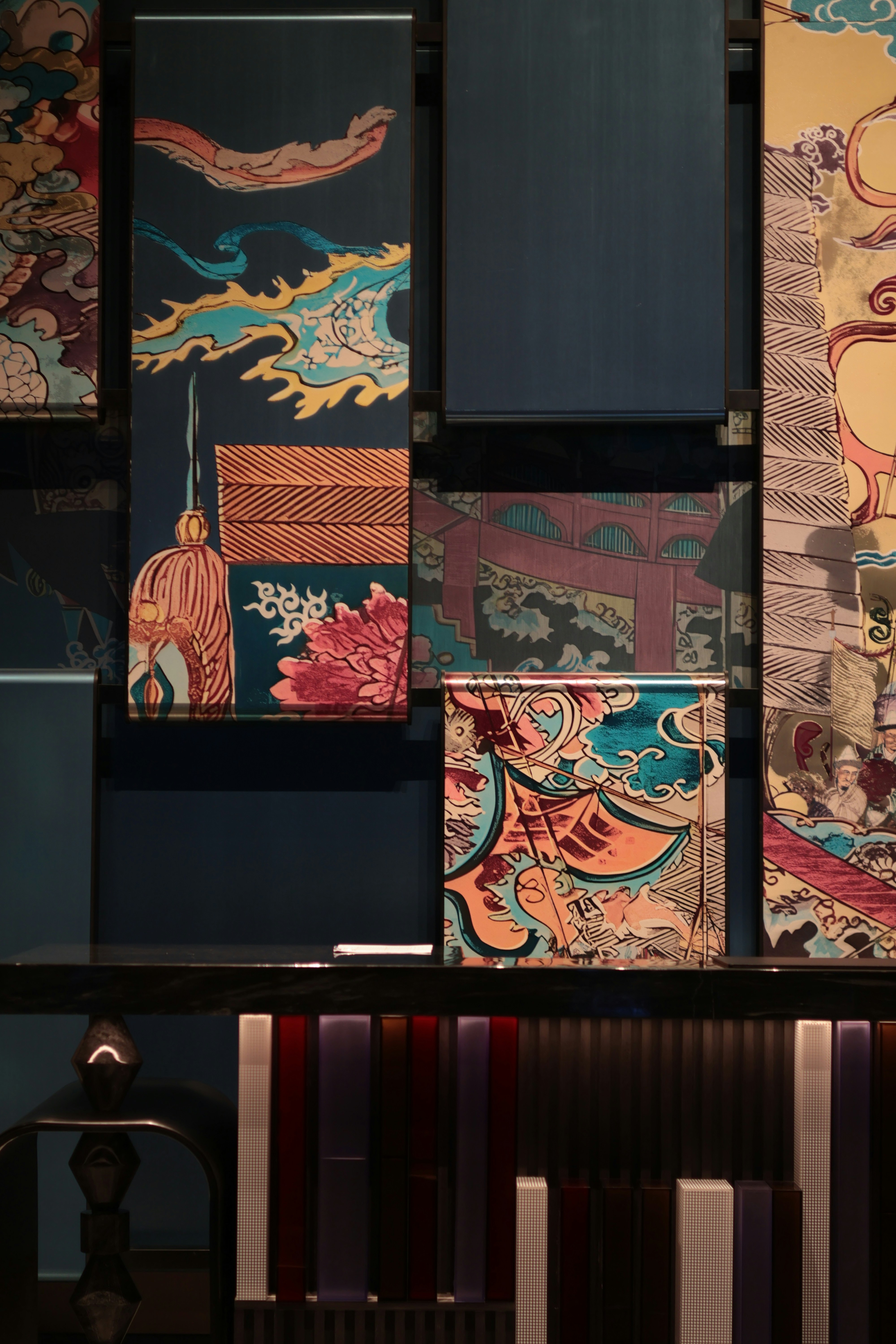 Decorative panels with colorful Japanese style illustrations above a dark modern console table