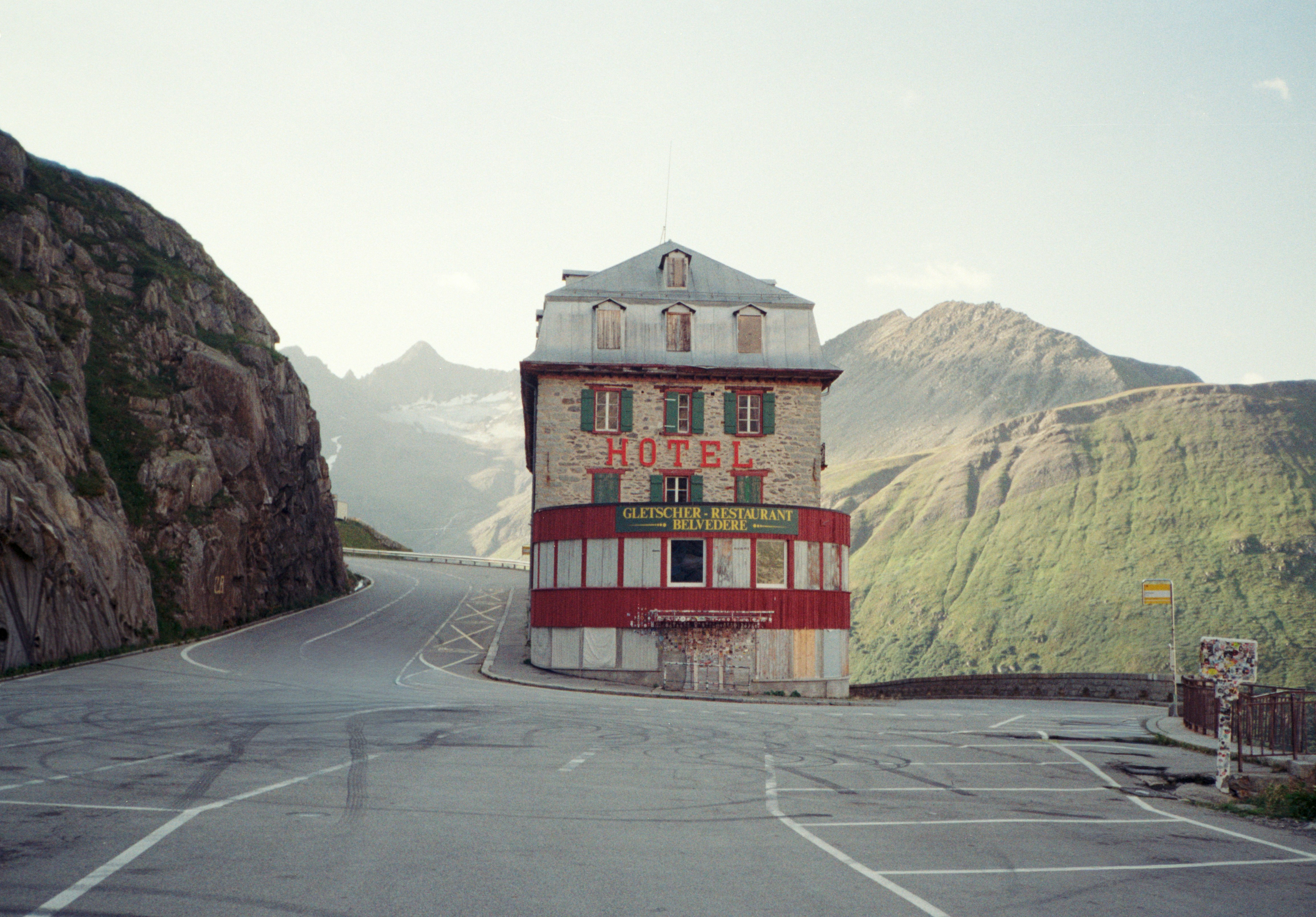 The Hotel Belvedere with red signage on a mountain pass in the Swiss Alps