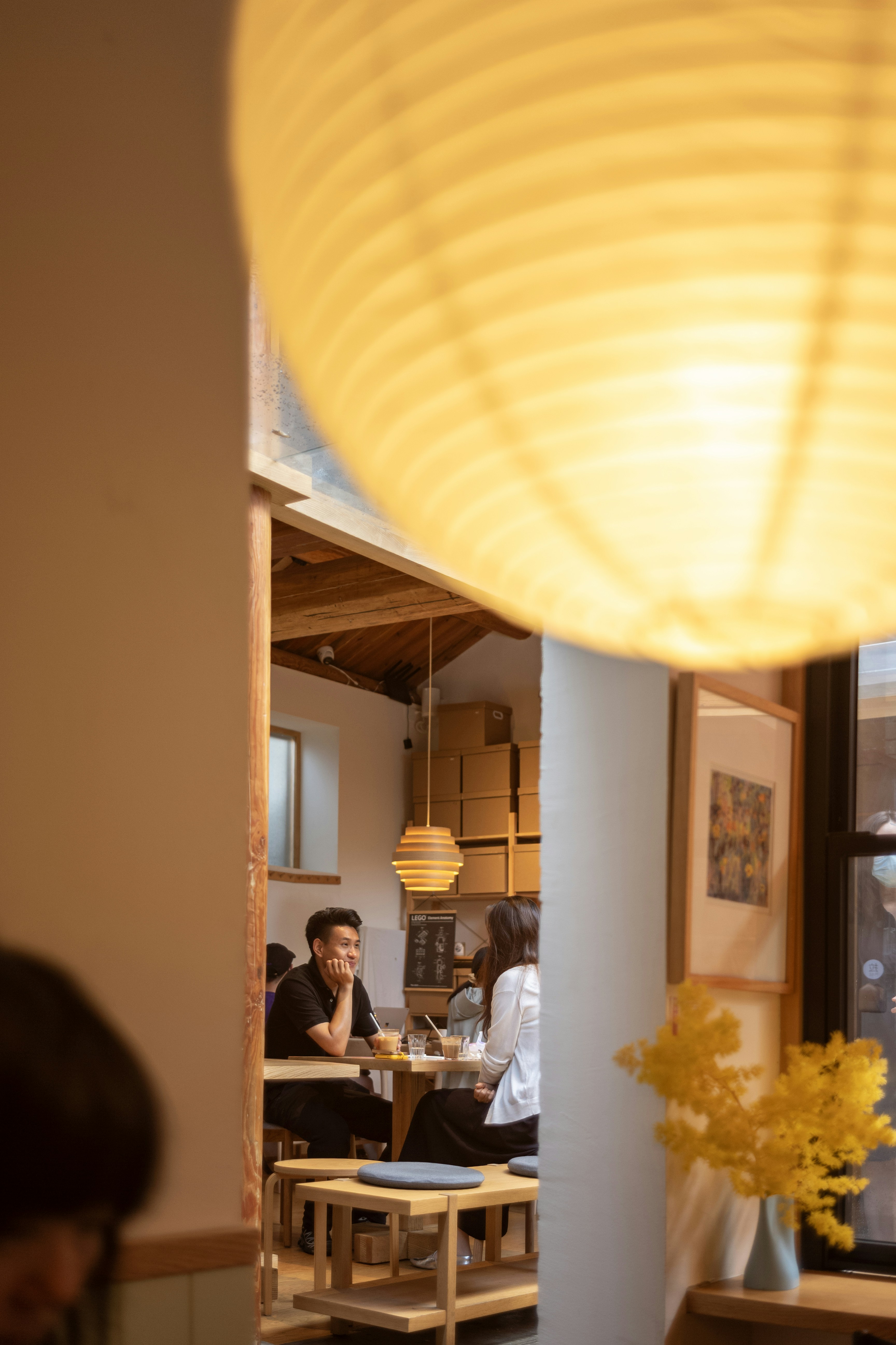 A man and a woman sitting at a wooden table in a cafe