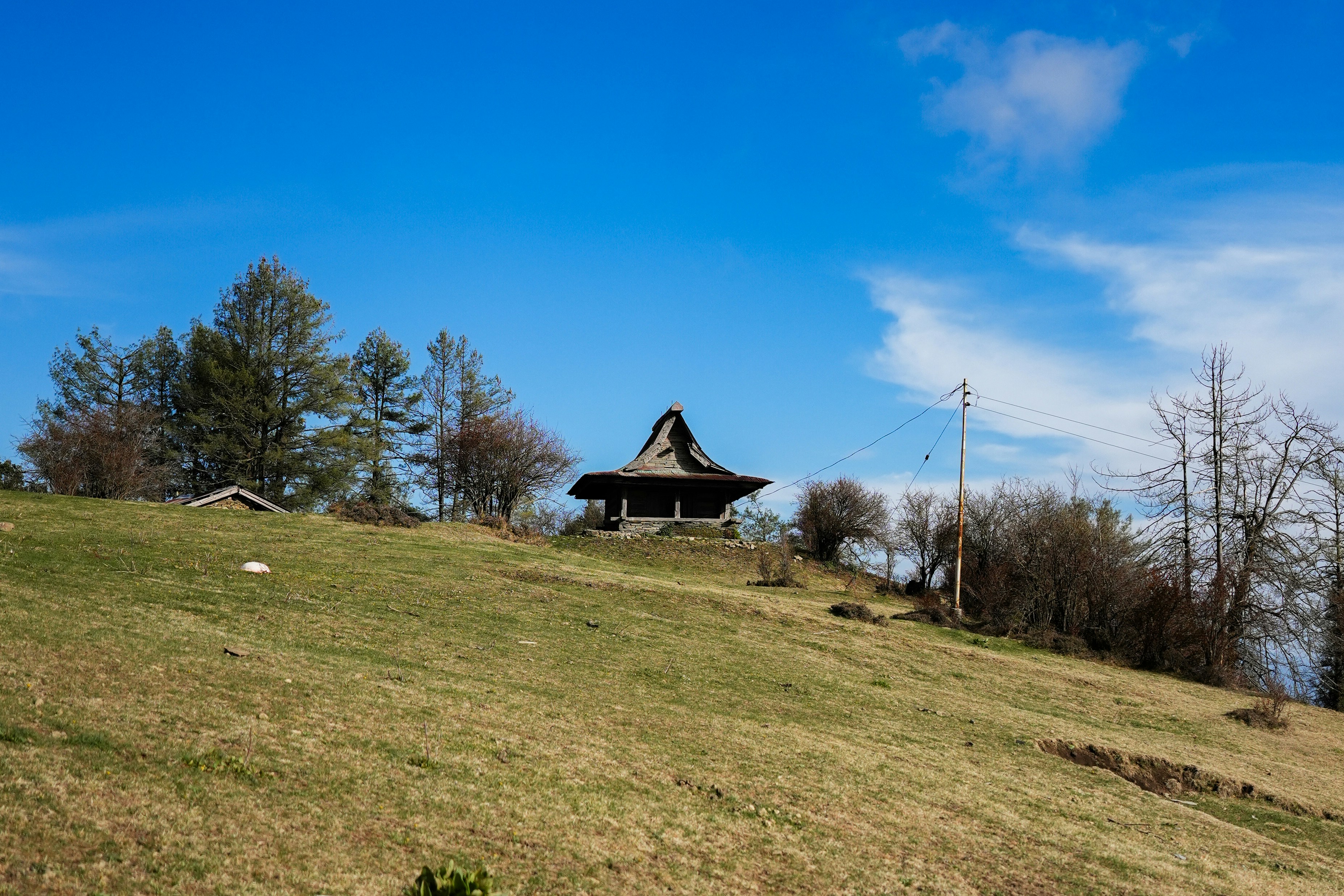 Wooden structure on grassy hillside - Free Photo on Unsplash
