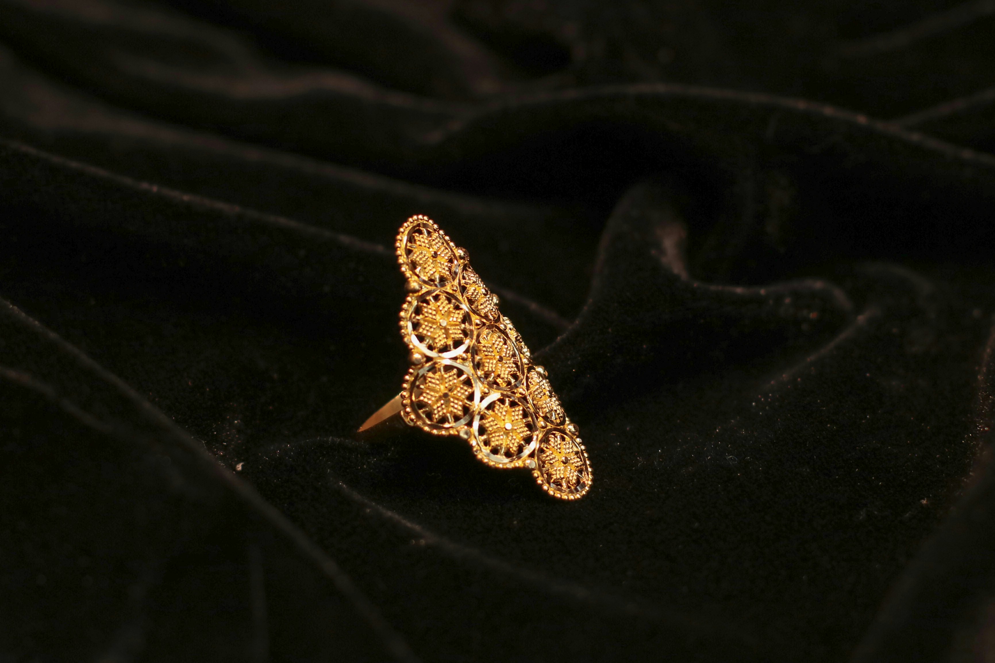 Ornate gold ring with filigree on black velvet