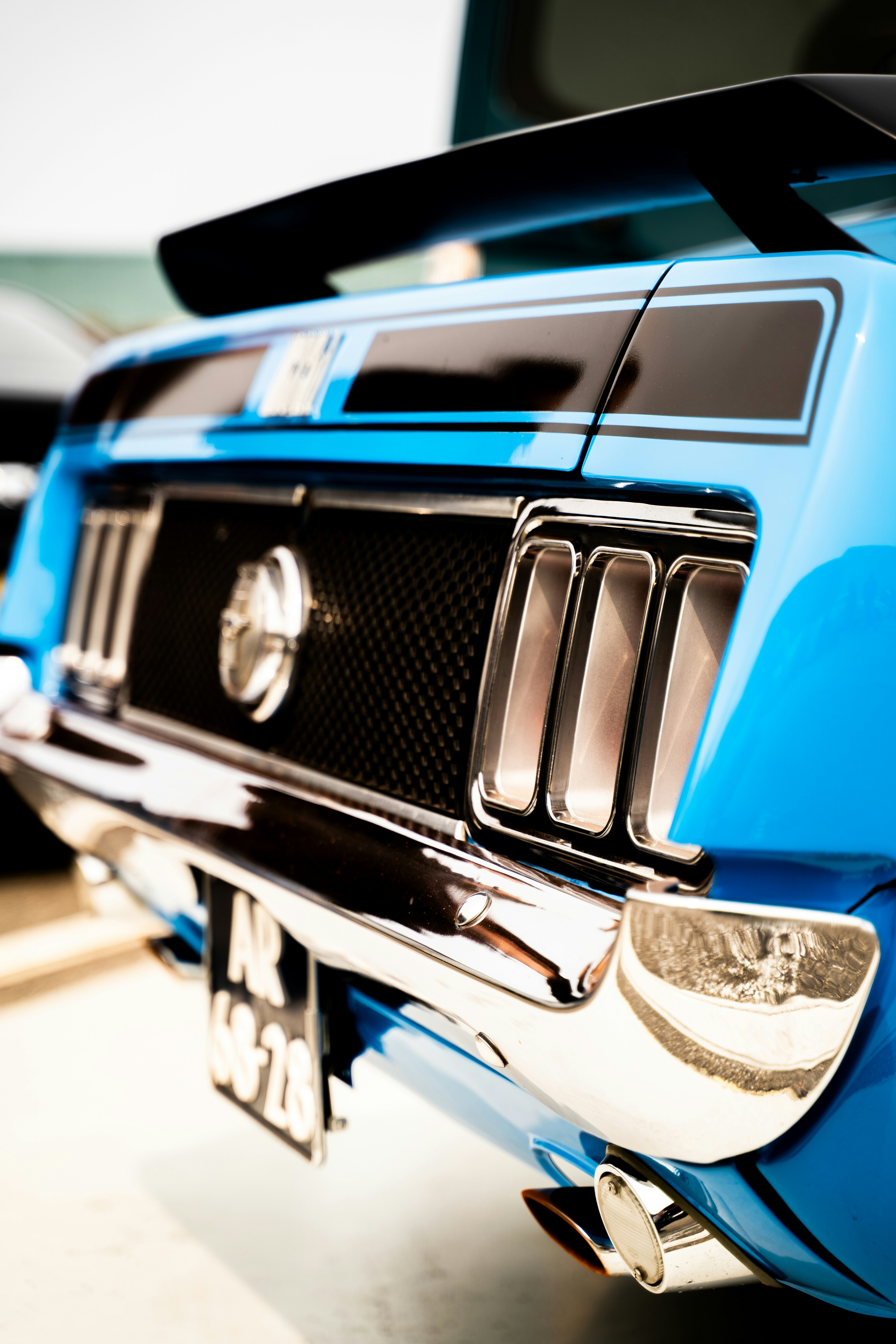 A traseira de um muscle car vintage azul brilhante com acabamento cromado