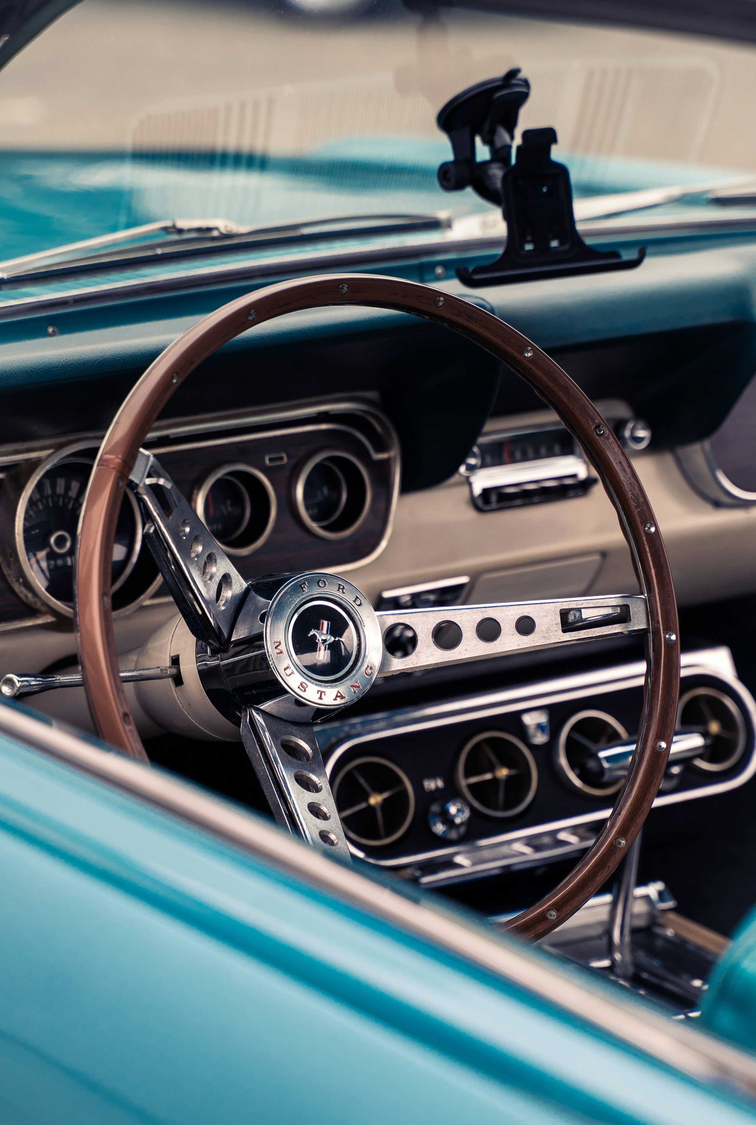 O interior de um Ford Mustang vintage com volante de madeira