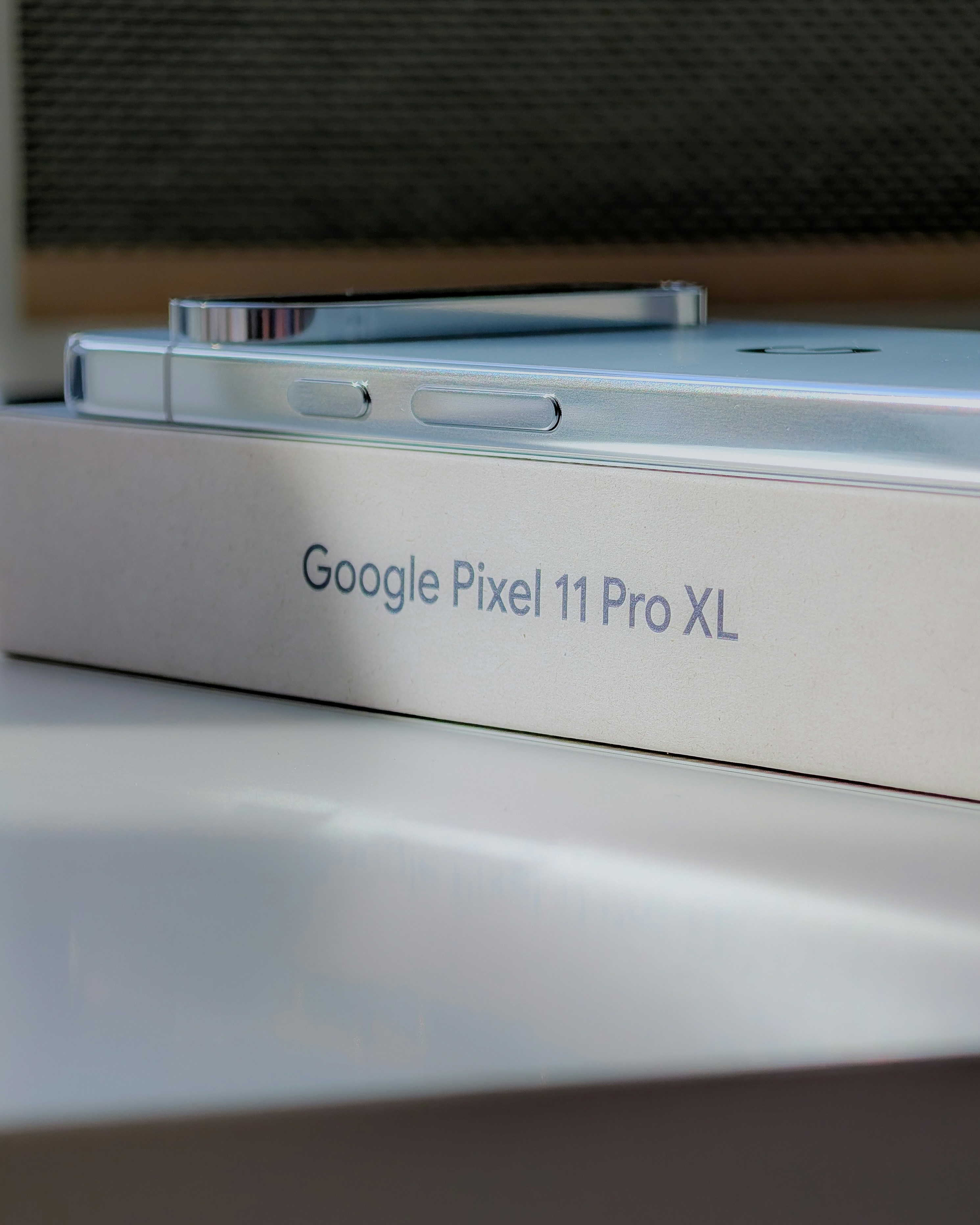 A smartphone resting on a white box labeled with text
