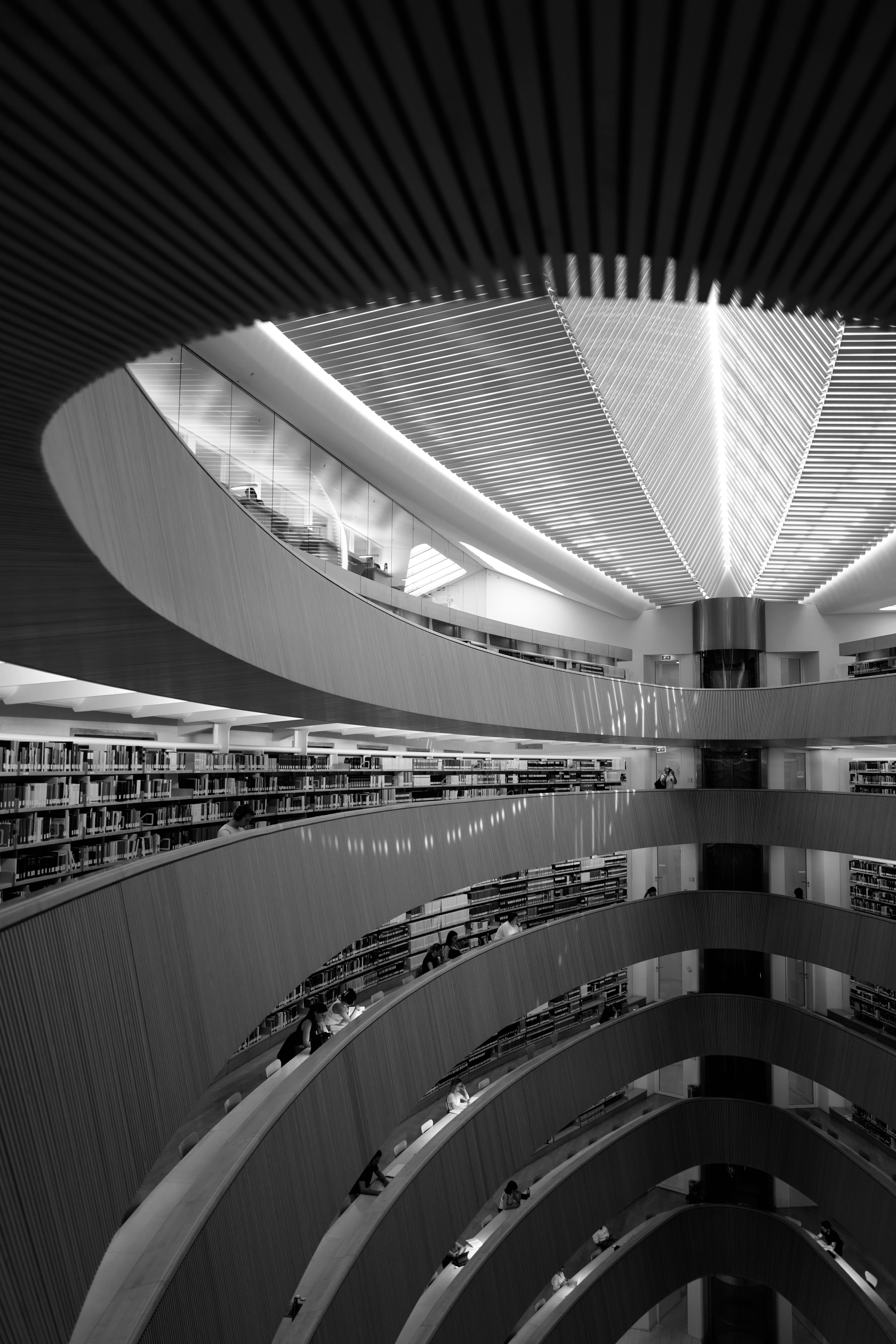 Balcons courbés de bibliothèque avec étagères et personnes à Zurich, Suisse