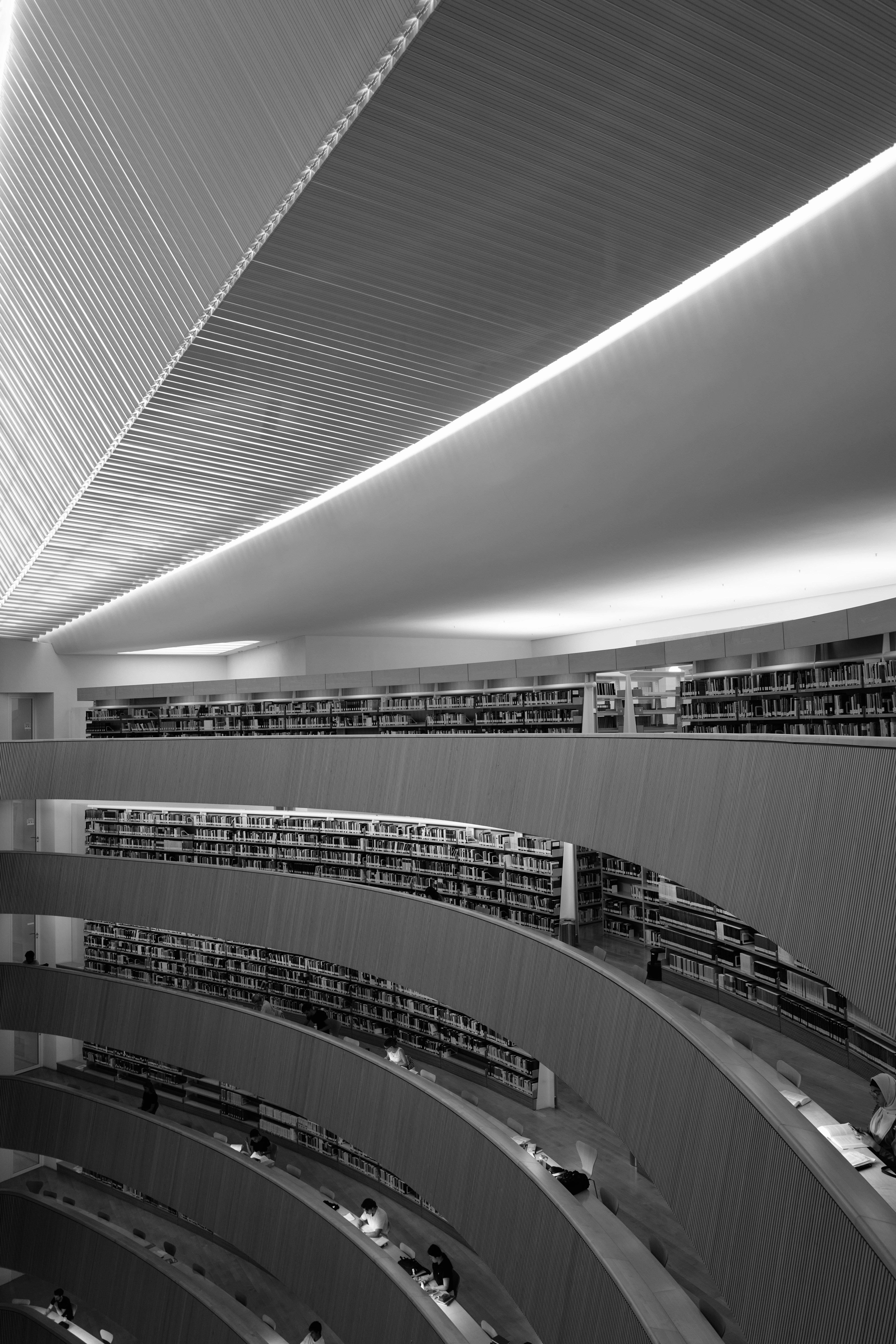 Balcons courbés de bibliothèque avec des rangées de livres et des étudiants à Zurich