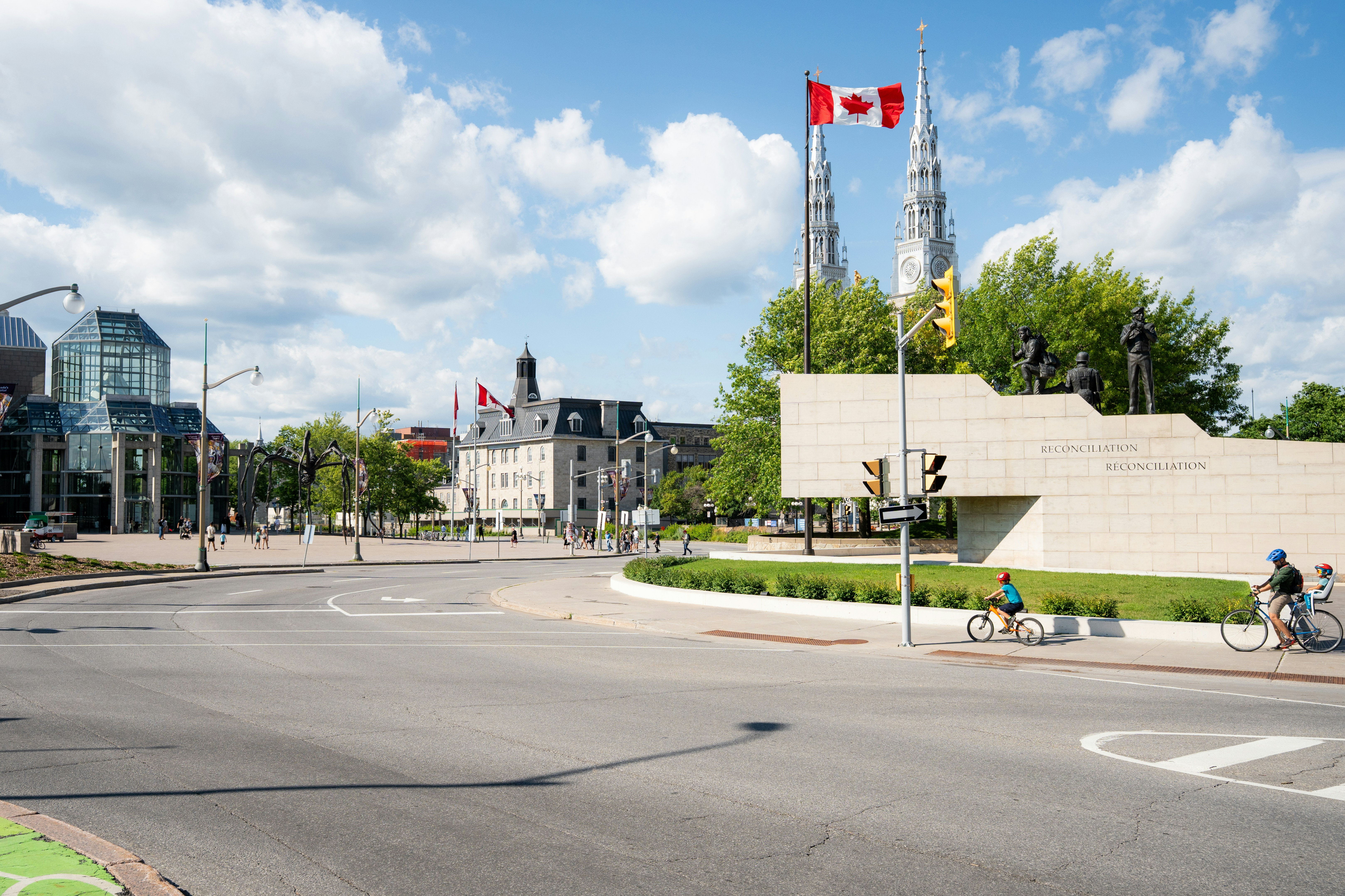 Cyclists on a road near the Reconciliation monument and National Gallery in Ottawa