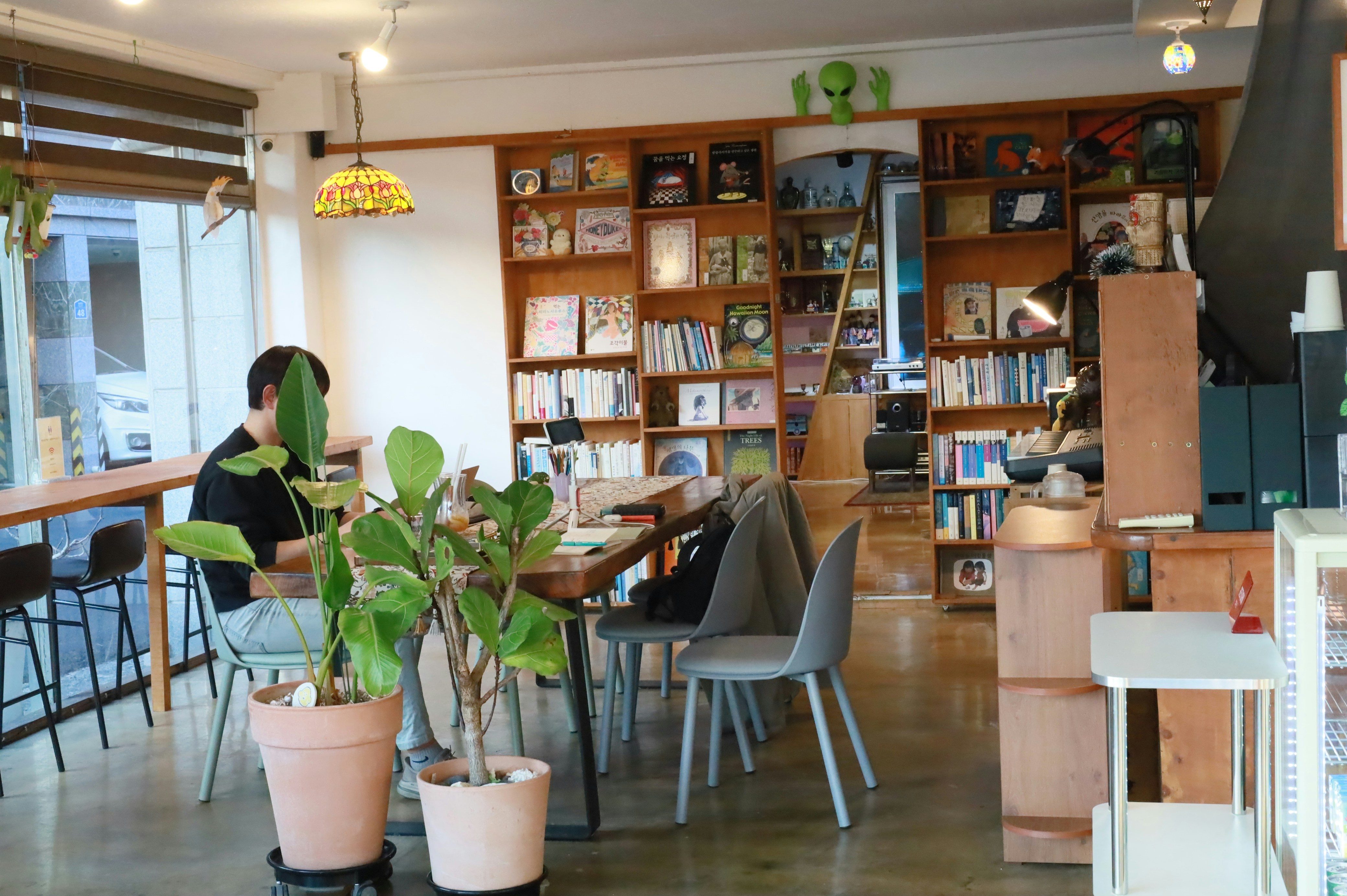 Person working at a wooden table in a bright cafe