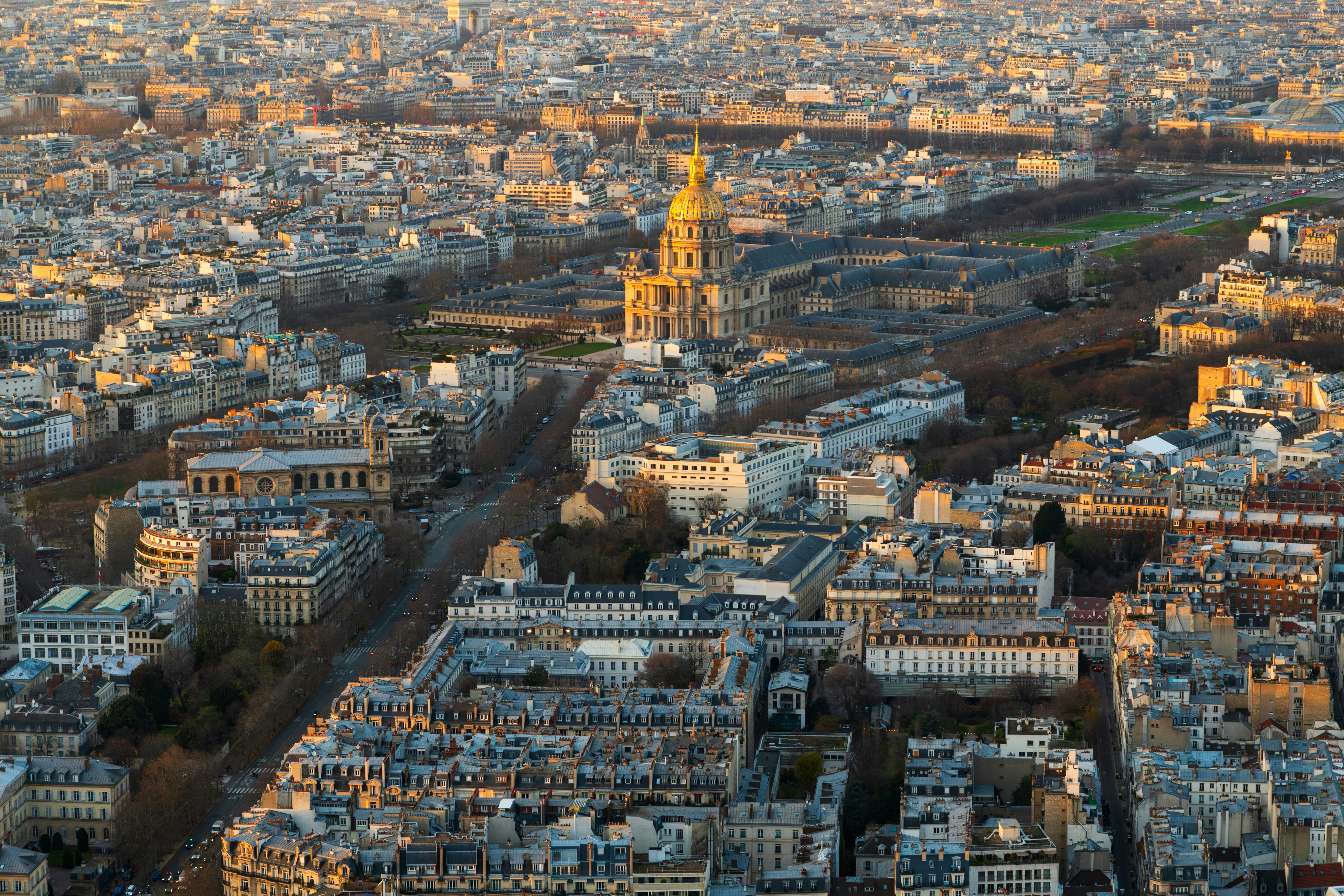 An aerial view of Les Invalides and the surrounding cityscape in Paris at golden hour
