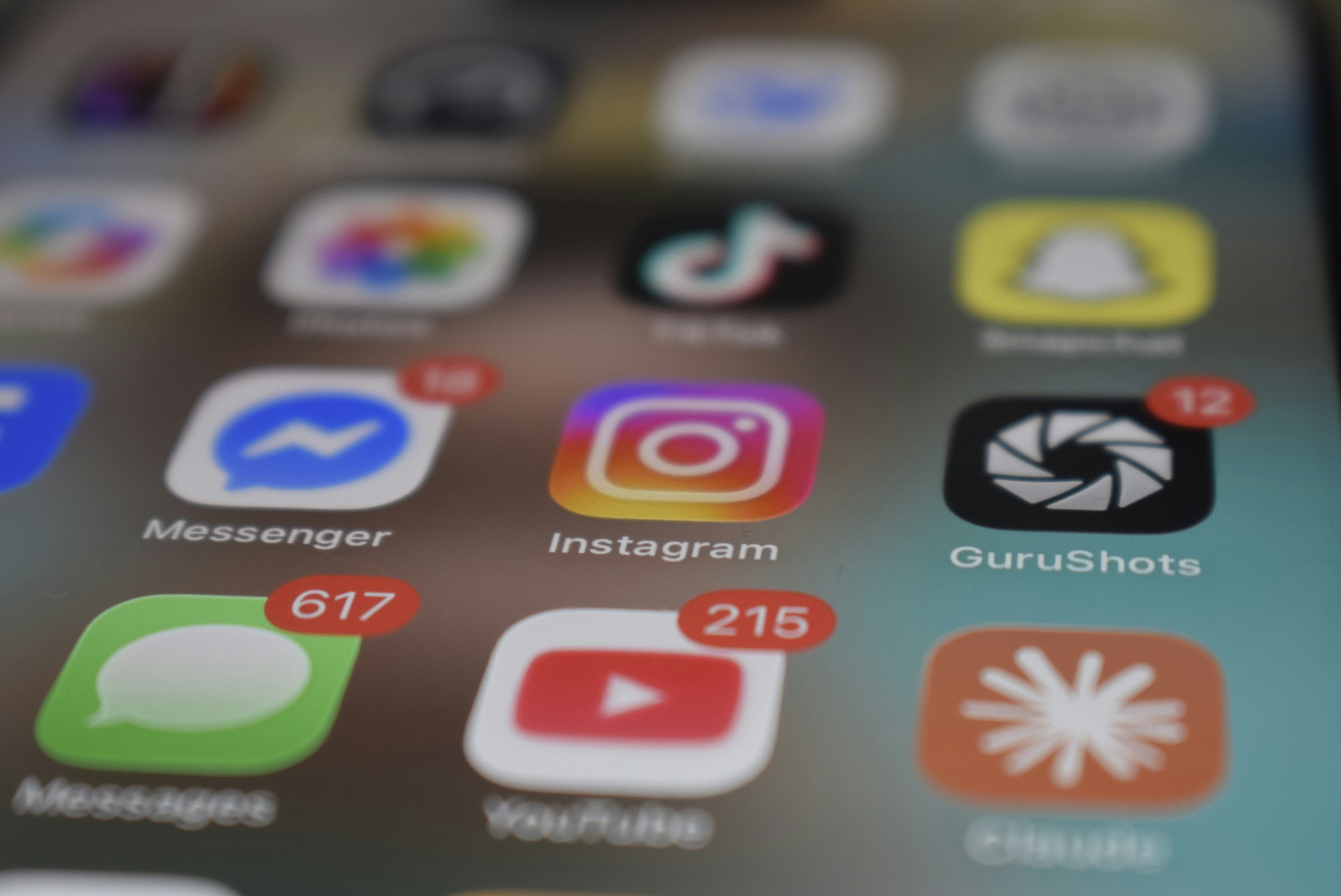 A smartphone screen displaying various social media app icons with red notification badges