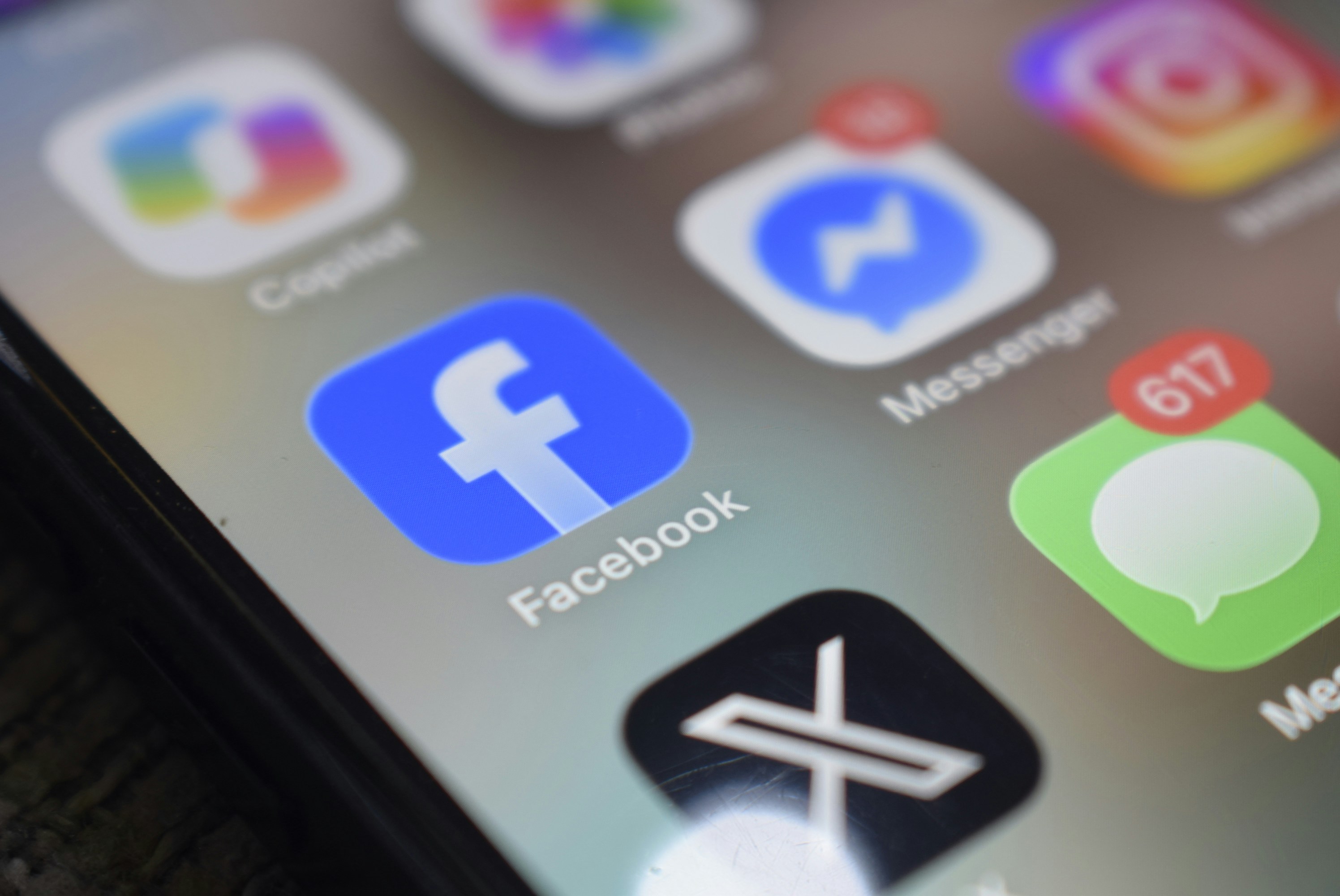 Uno schermo per uno smartphone che mostra varie icone di app social media, tra cui Facebook e Messenger