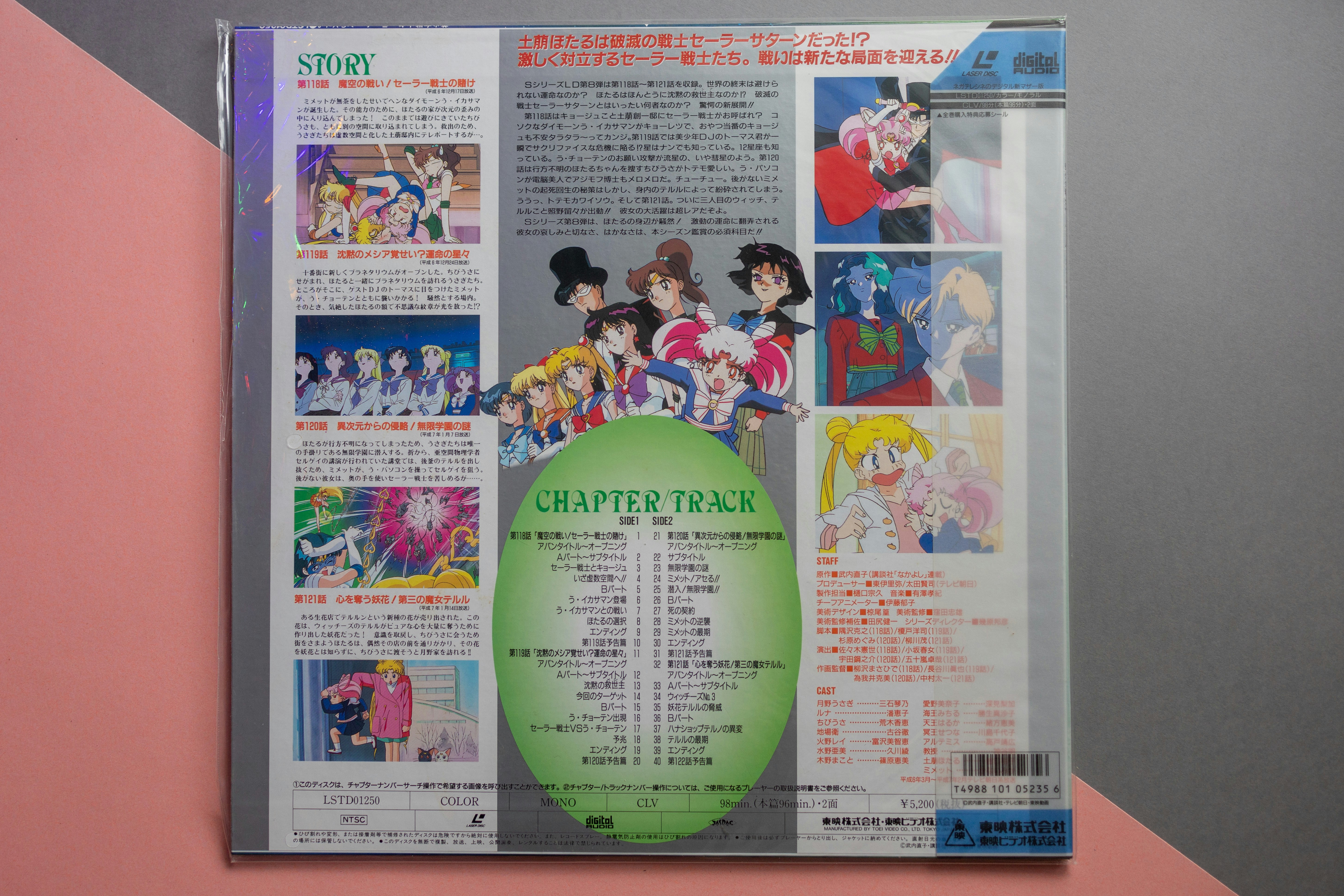 Uma capa de laserdisc Sailor Moon com personagens de anime e texto japonês sobre fundo branco