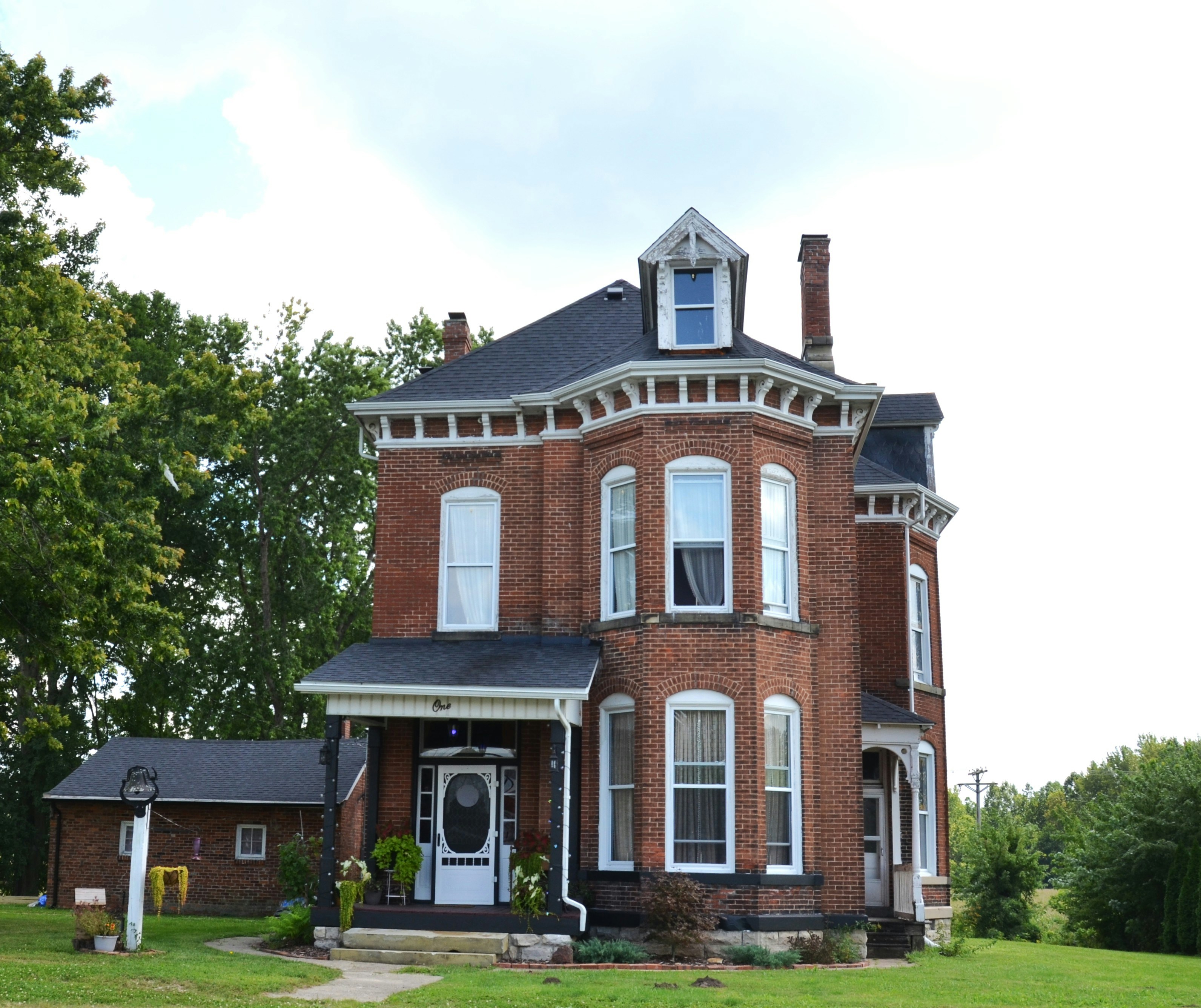 Red brick Victorian house with a front porch