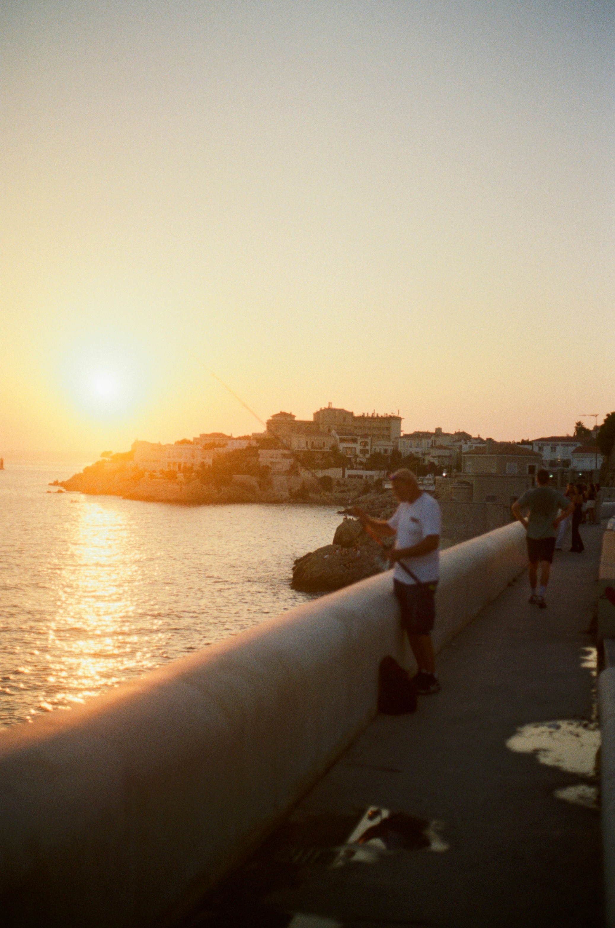 A person fishing from a concrete pier during the golden hour in Marseille - 相关推荐