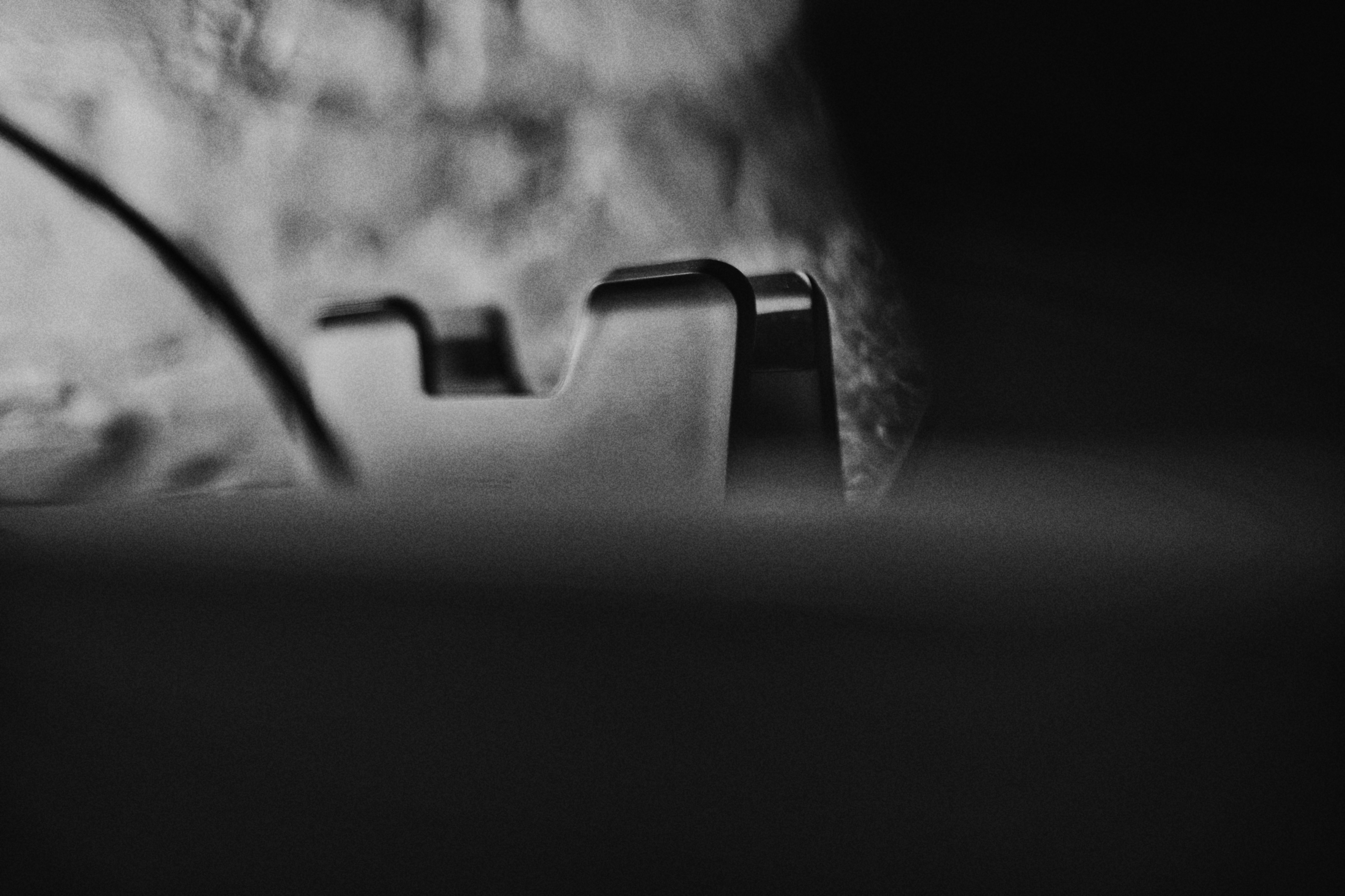 A black tape dispenser on a dark surface with a blurred background