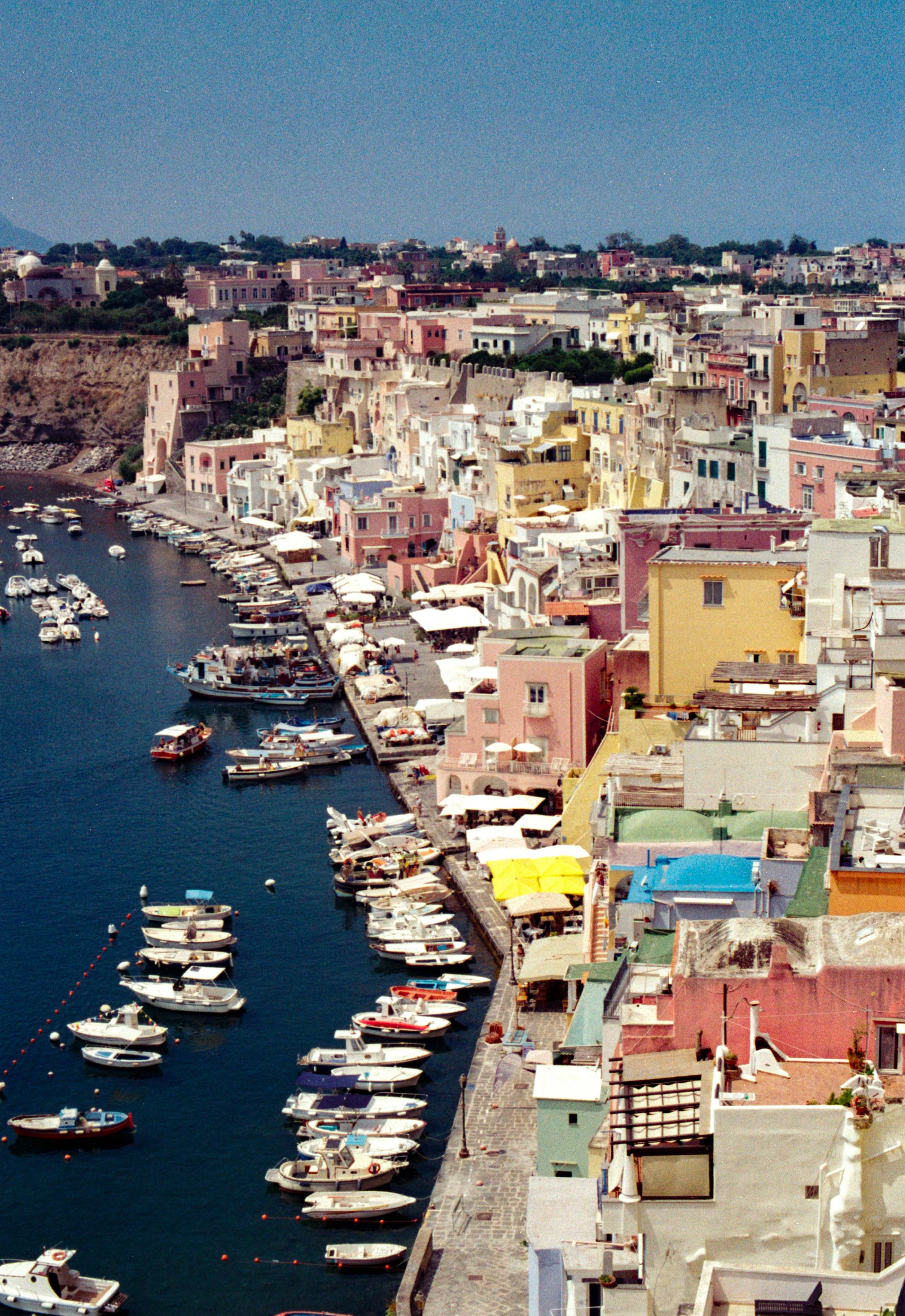 Barcos amarrados a lo largo de un colorido malecón en Procida, Italia