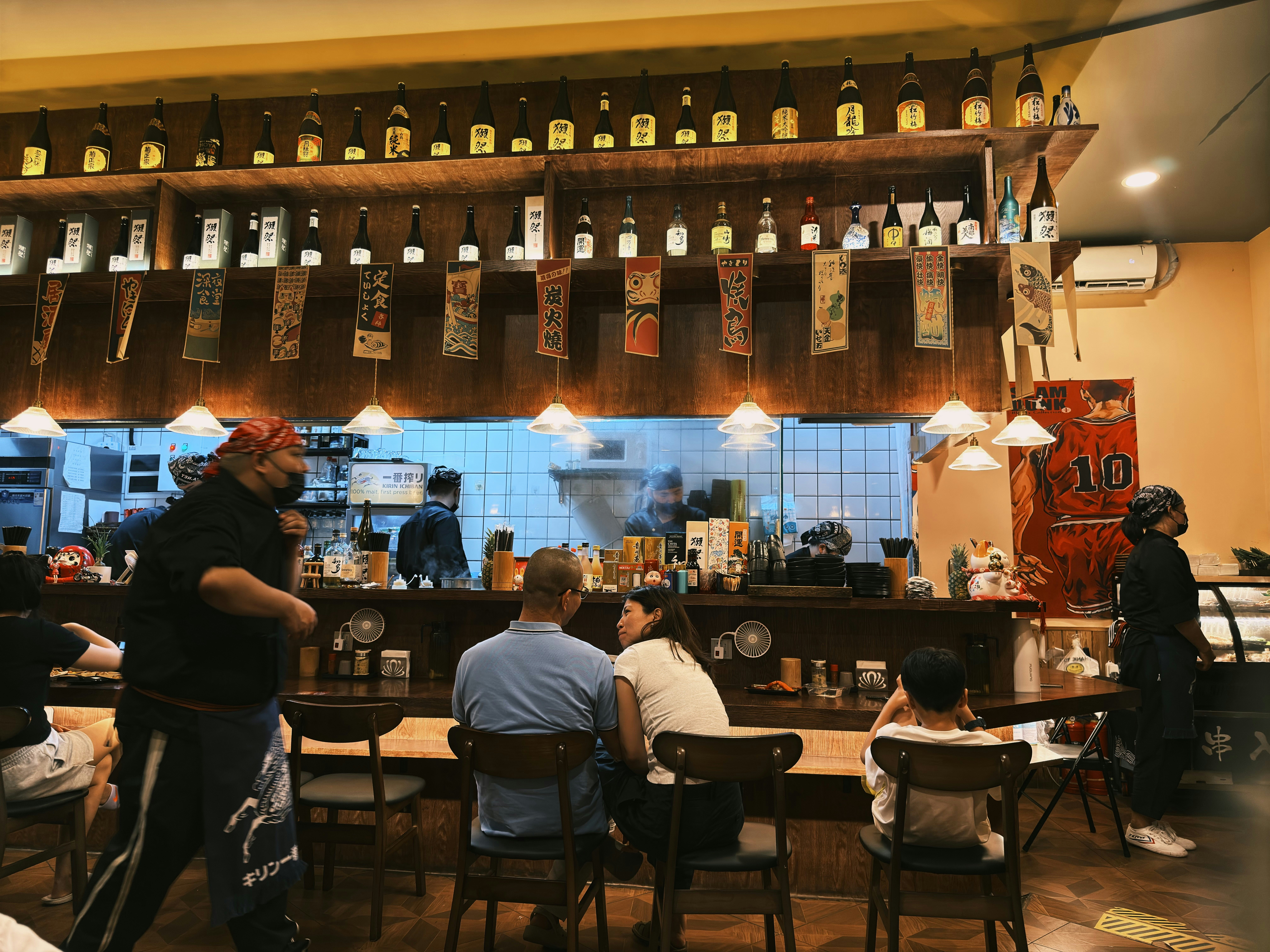 Diners at a long wooden bar counter