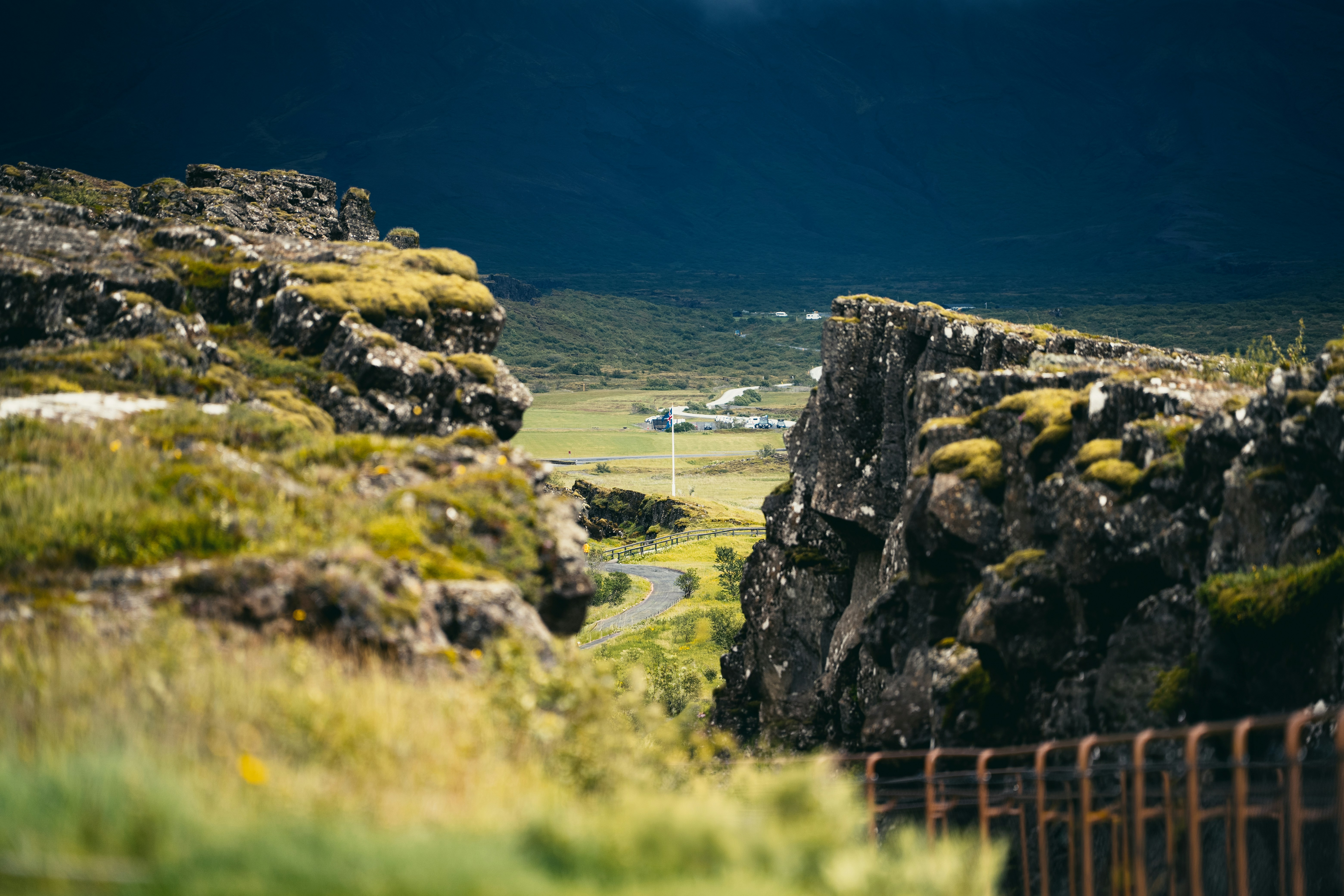 A winding road through a mossy rocky gorge in Thingvellir National Park