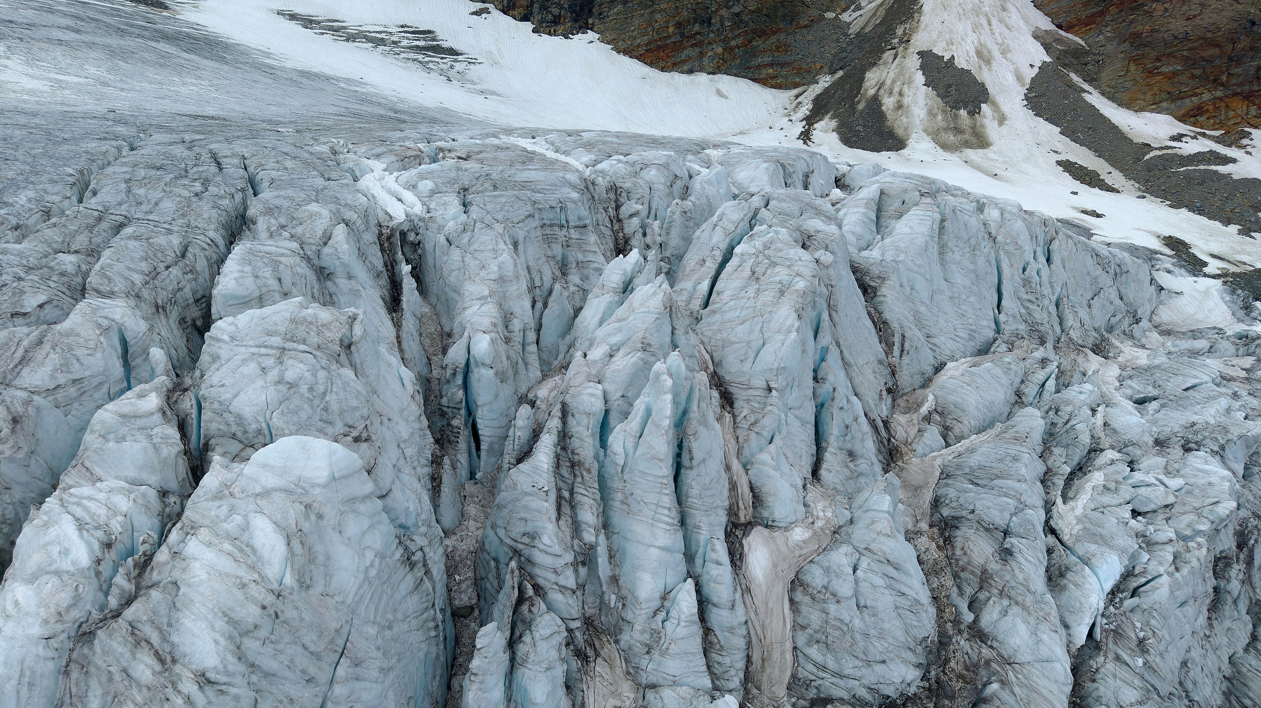 Deep blue crevasses and jagged ice formations on a mountain glacier