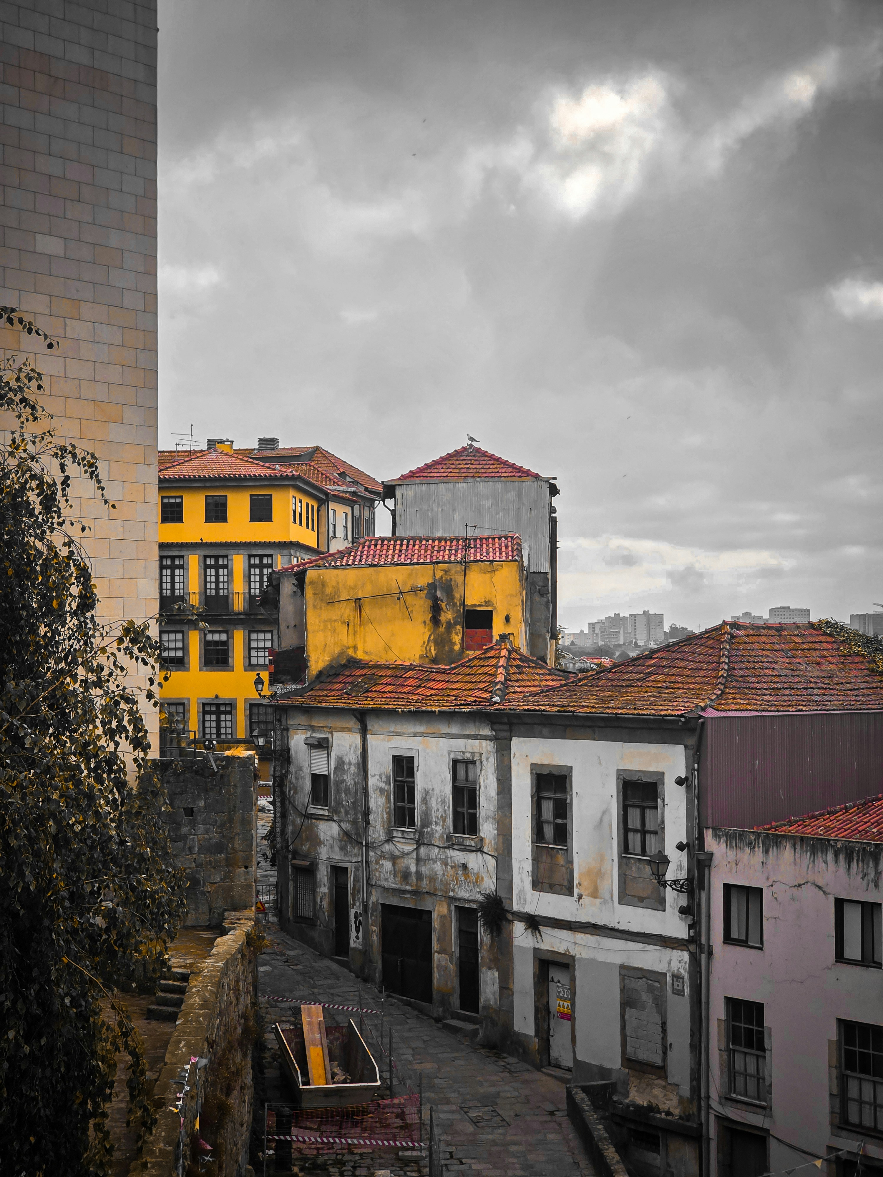 Old buildings with yellow and white facades along a narrow stone street