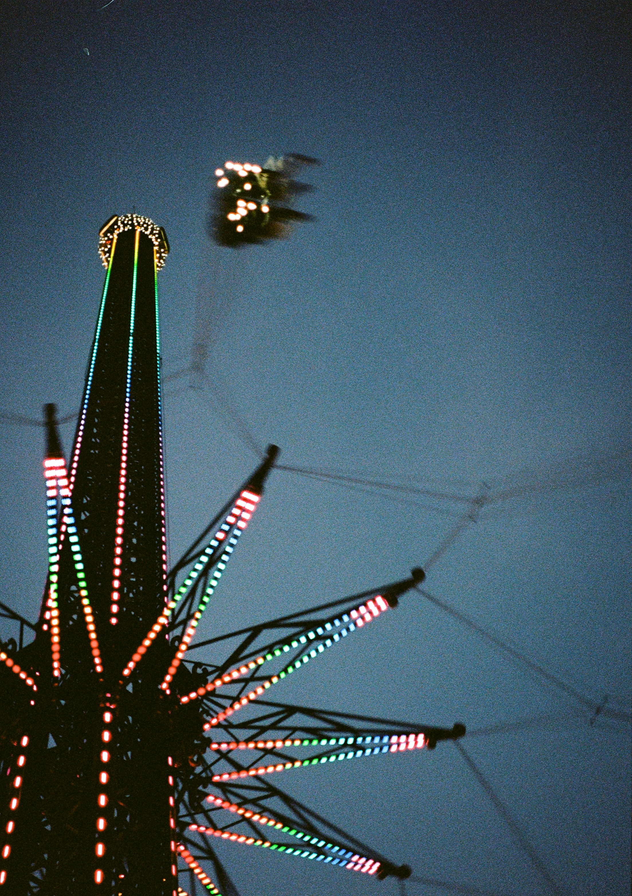 A tall illuminated swing ride at night in the Prater amusement park in Vienna