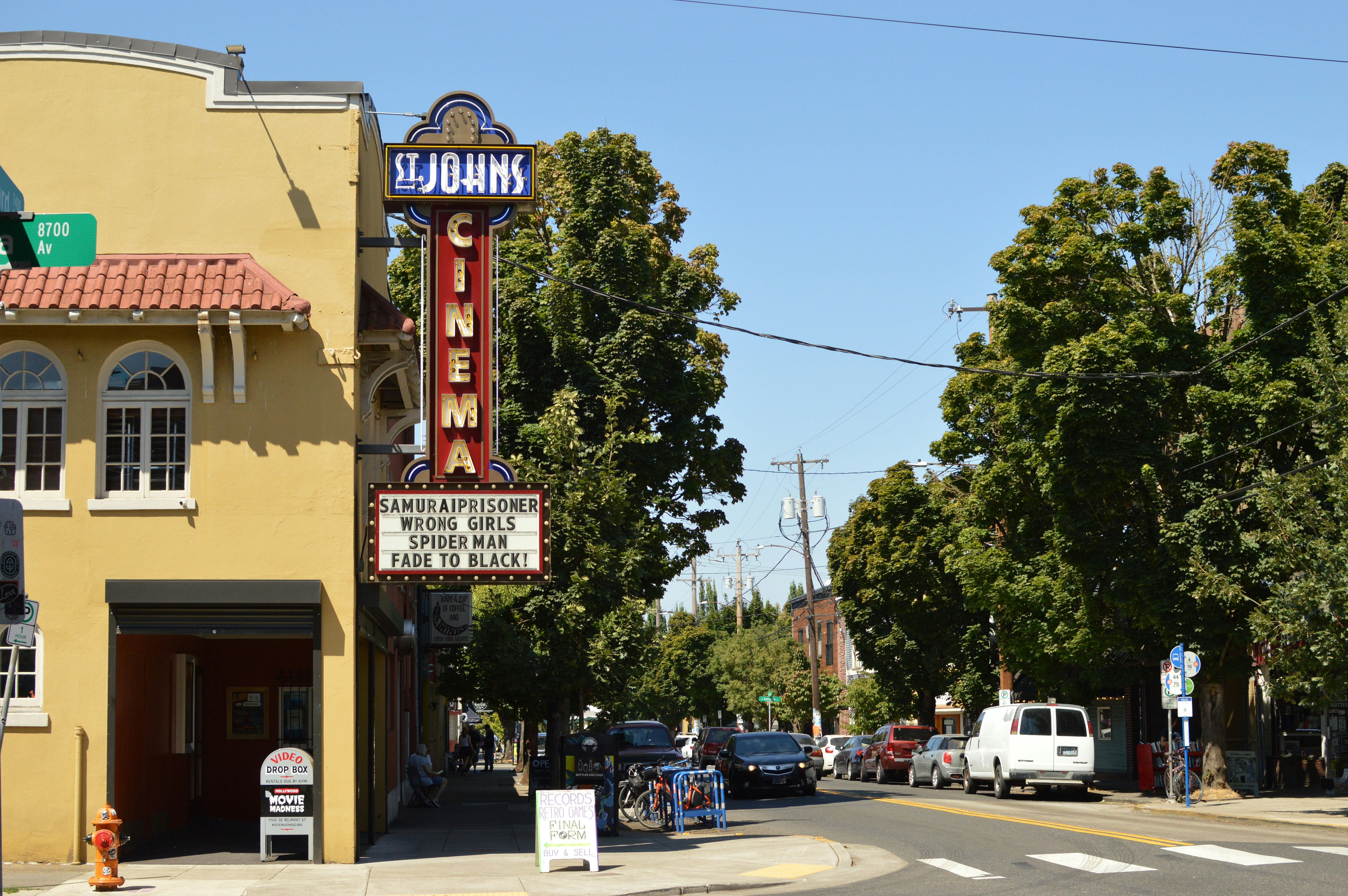 A St. Johns Cinema marquee above a street with cars and trees