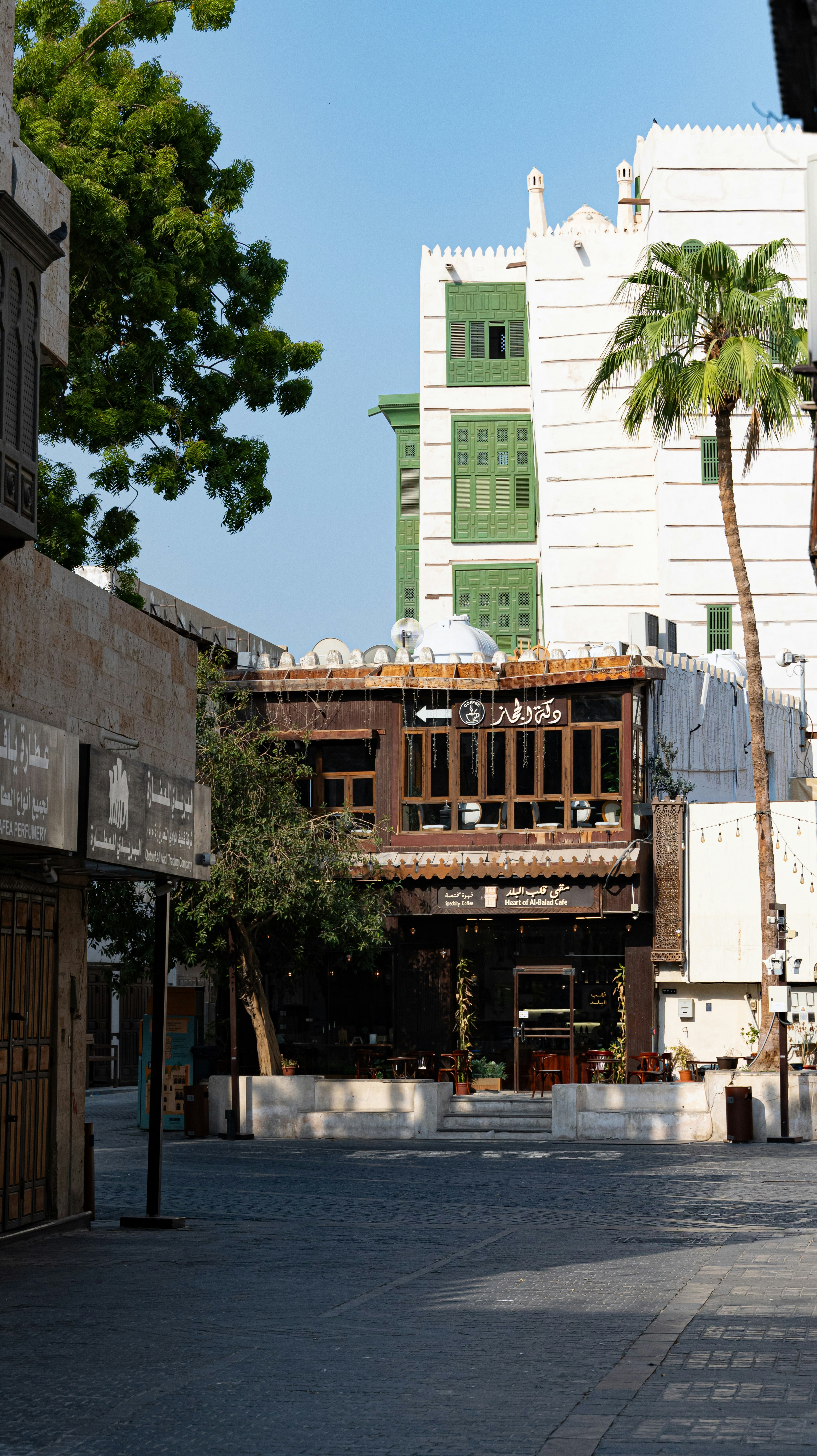 A cafe with wooden balconies and green shutters in the historic Al-Balad district
