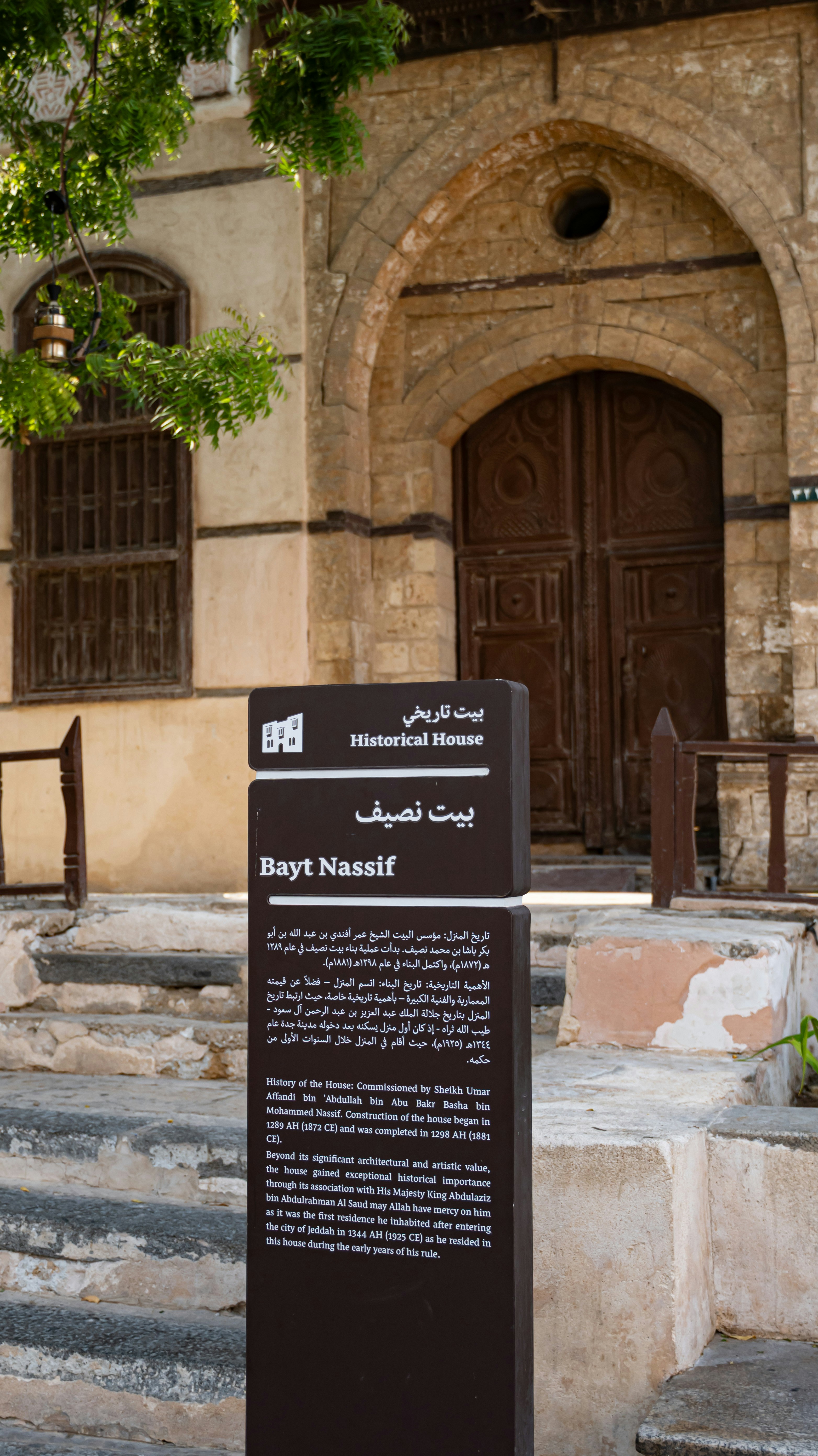 An information sign for Bayt Nassif in front of a historic stone building