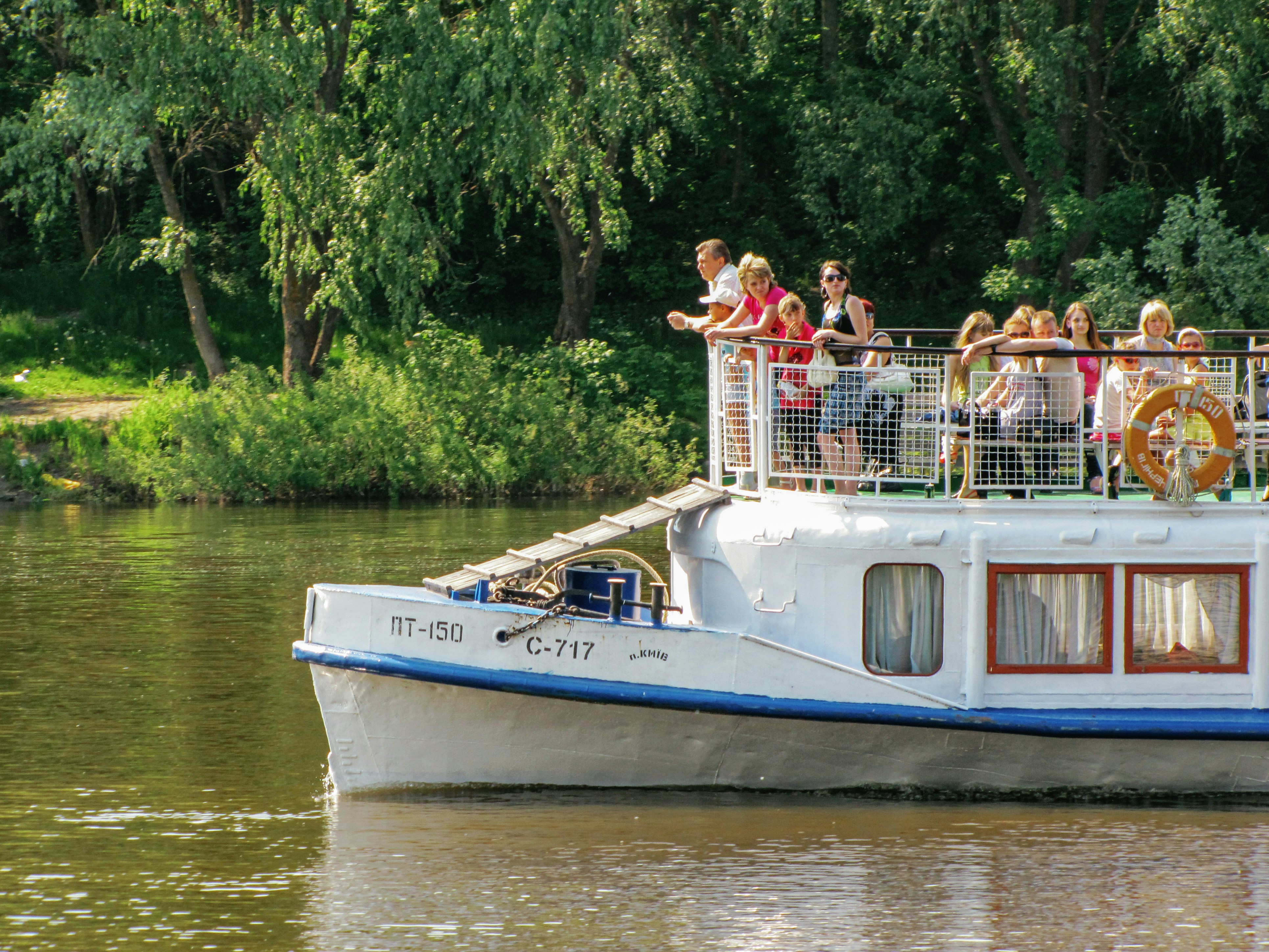 A group of people on the deck of a white river boat