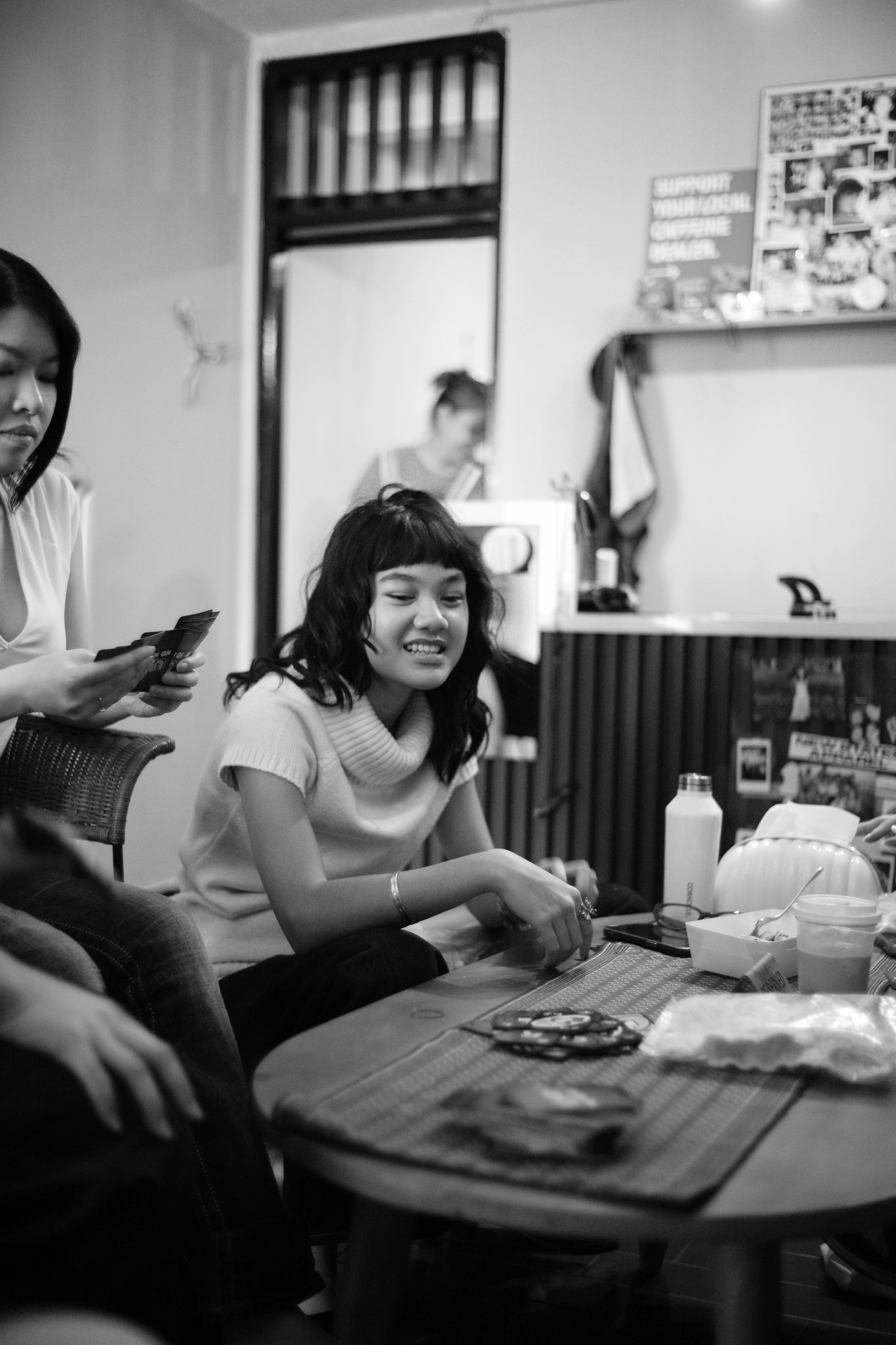 Pessoas jogando cartas em uma mesa em uma sala com porta